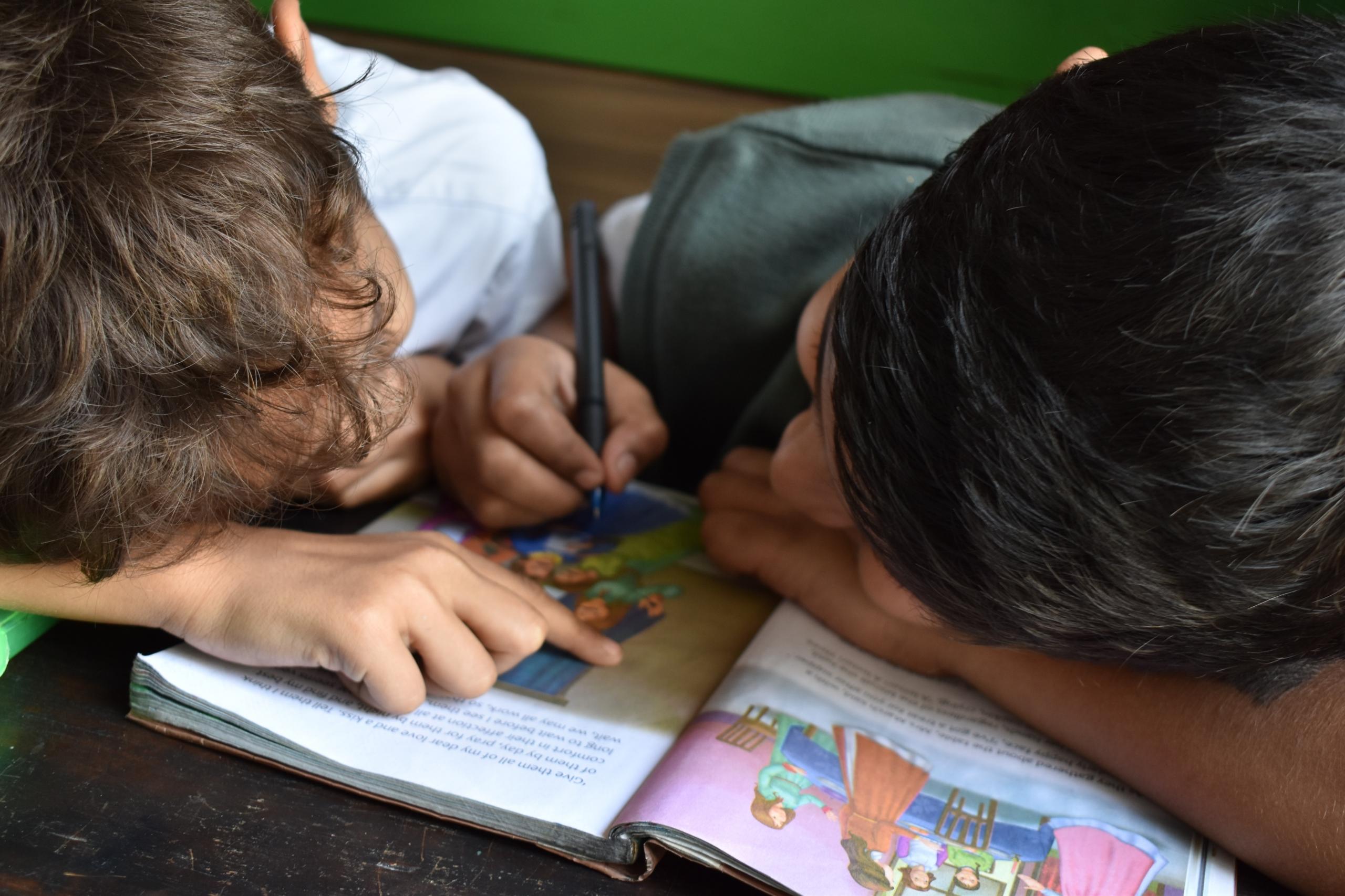 dos chicos leyendo un libro