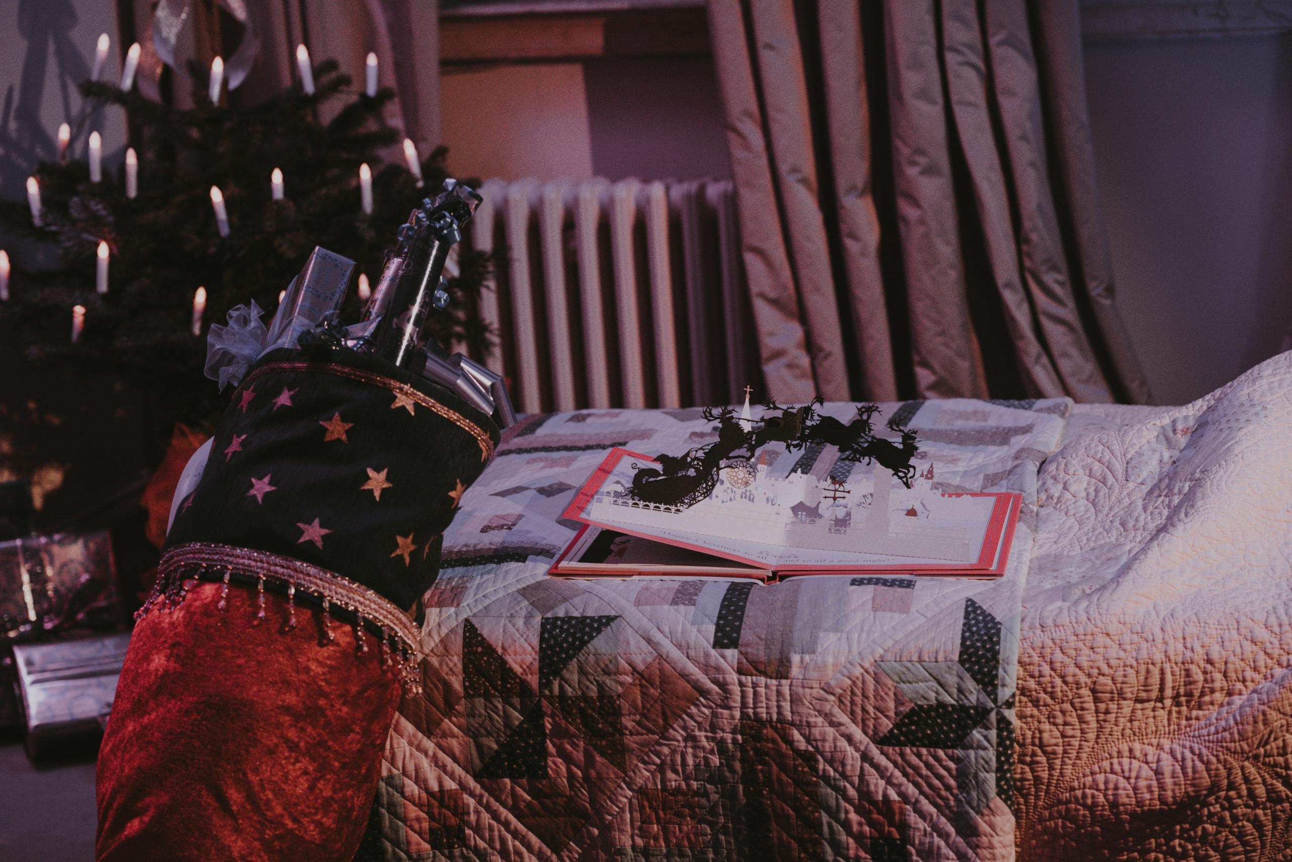 una cama con decoraciones navideñas y un libro pop-up abierto