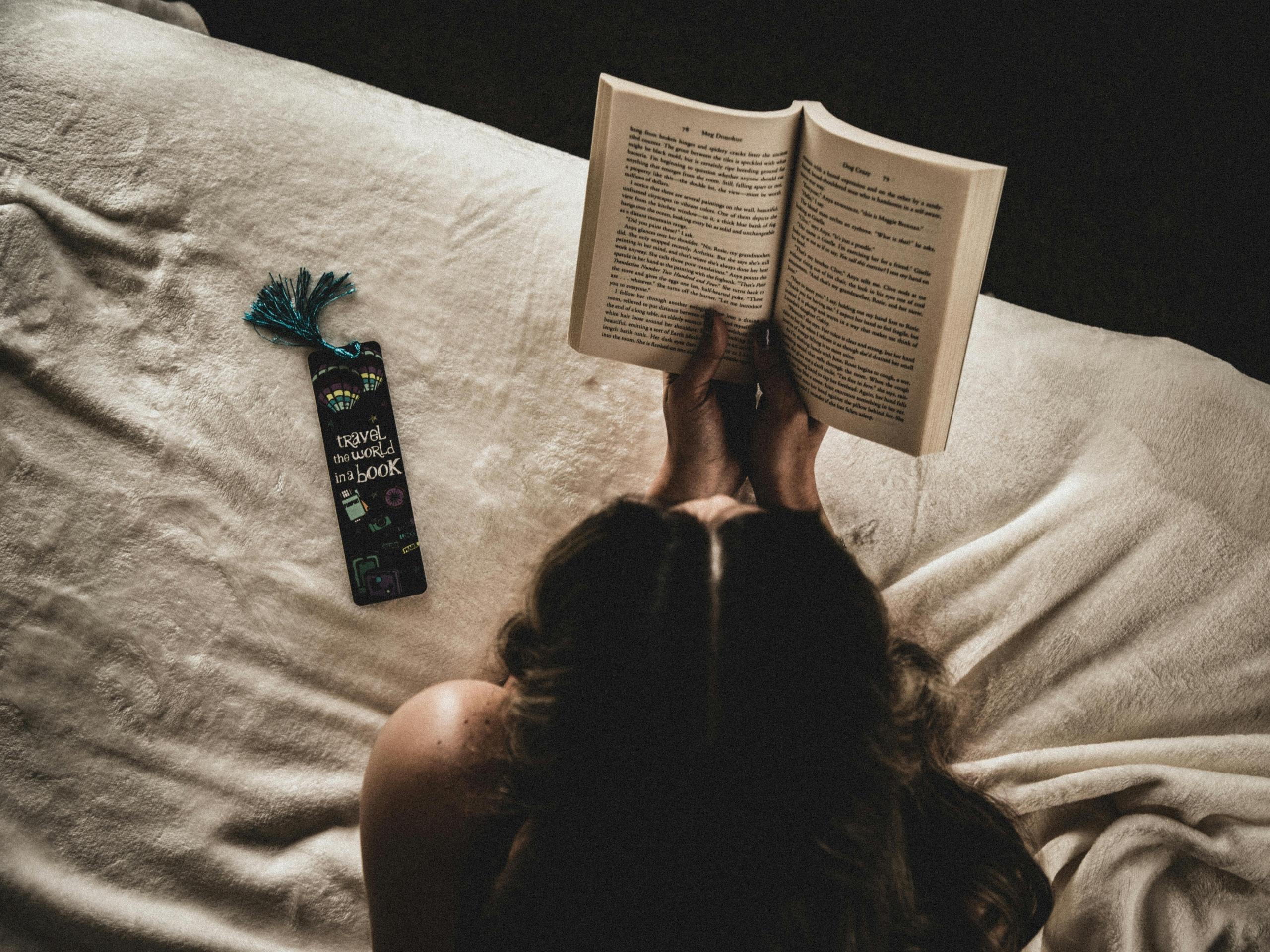 persona leyendo sobre la cama