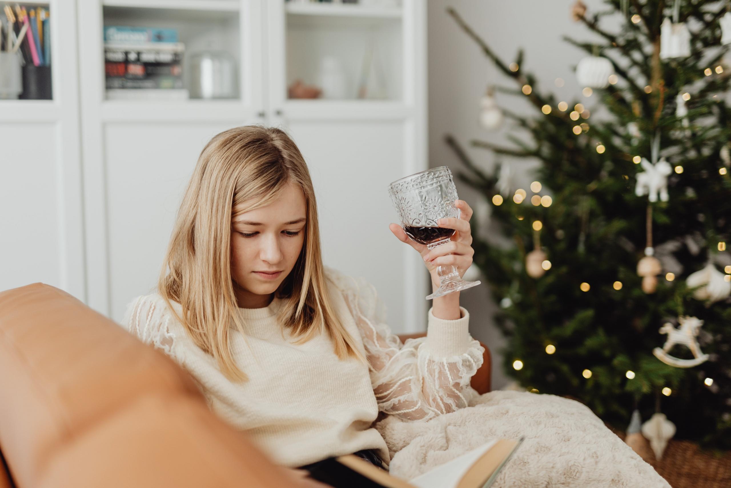 mujer leyendo un libro con árbol de navidad de fondo