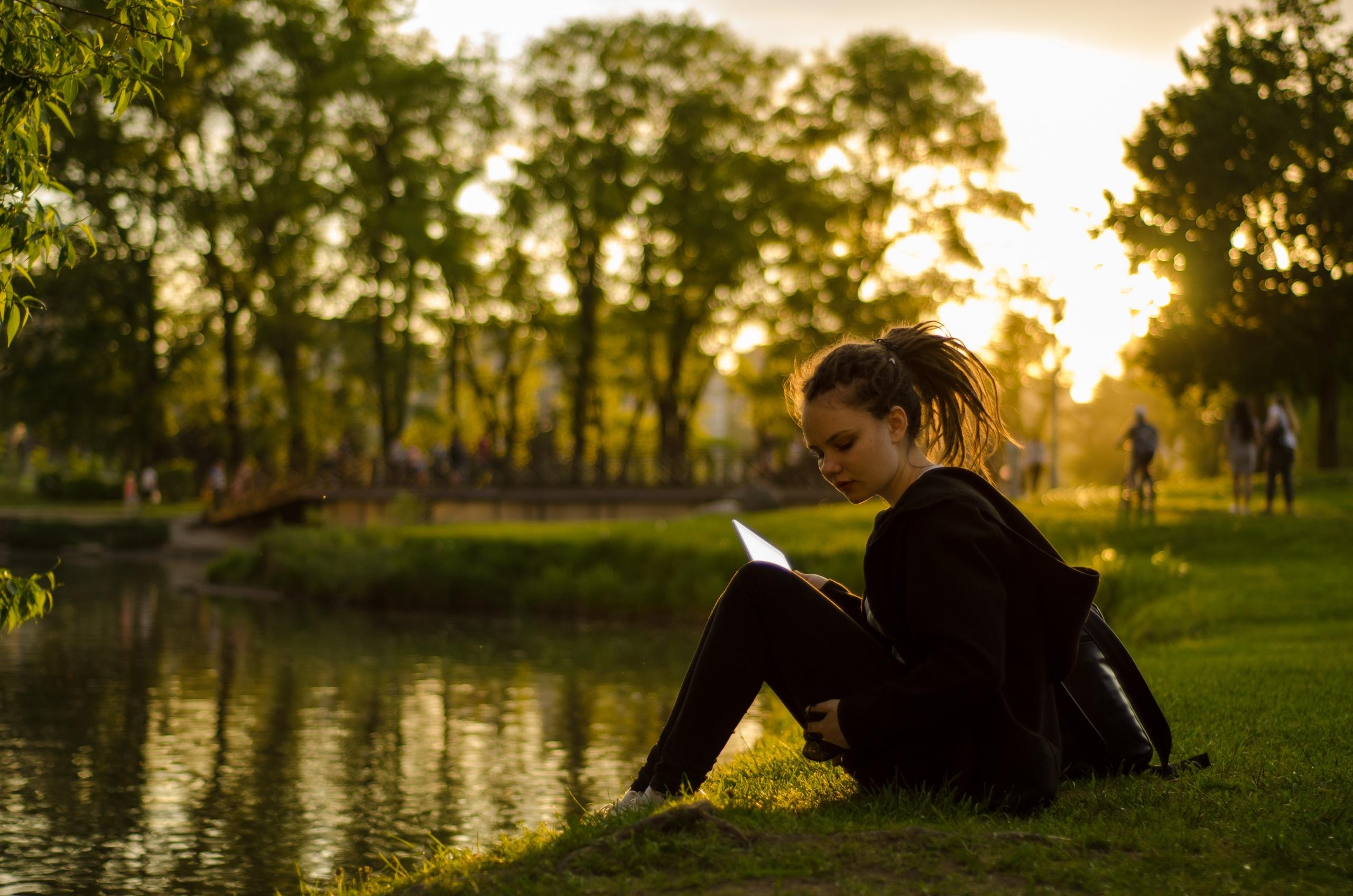 joven leyendo frente al agua