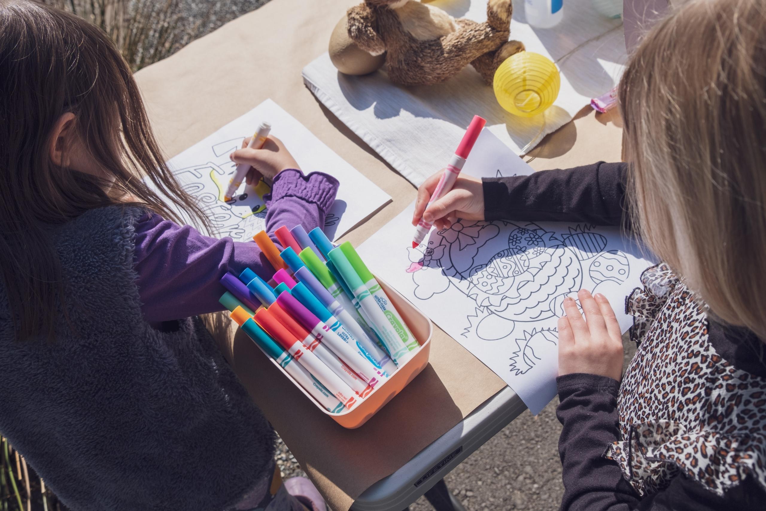 chicos pintando con marcadores de colores al sol