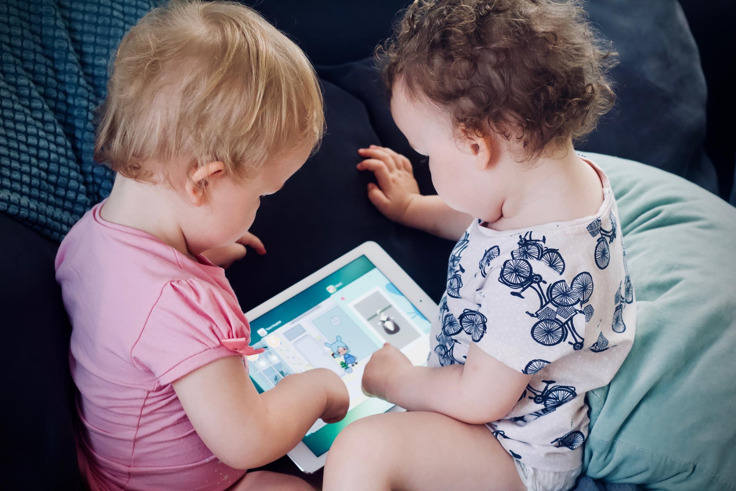 dos niños jugando con una tablet
