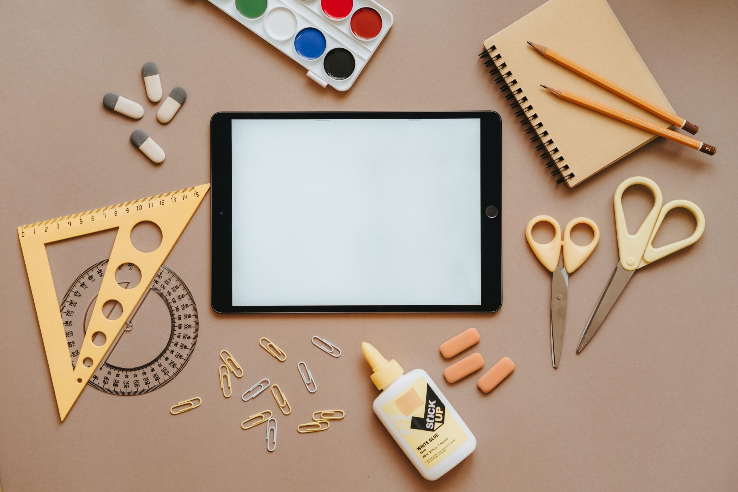 tablet junto a herramientas de dibujo y pintura