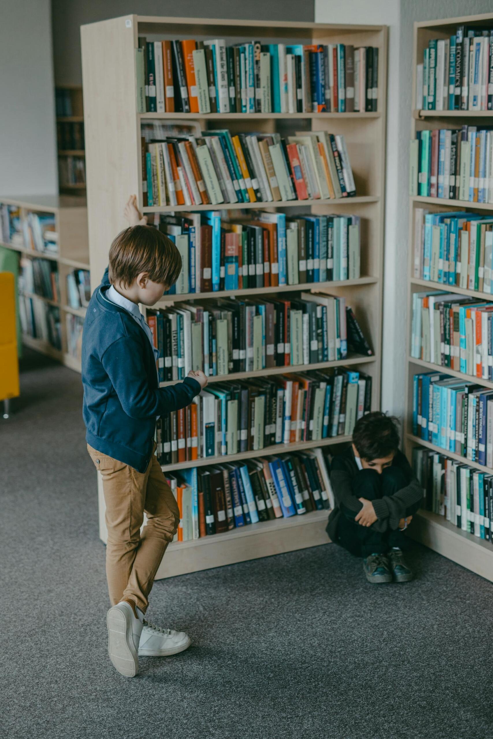 niño molestando a otro en una biblioteca