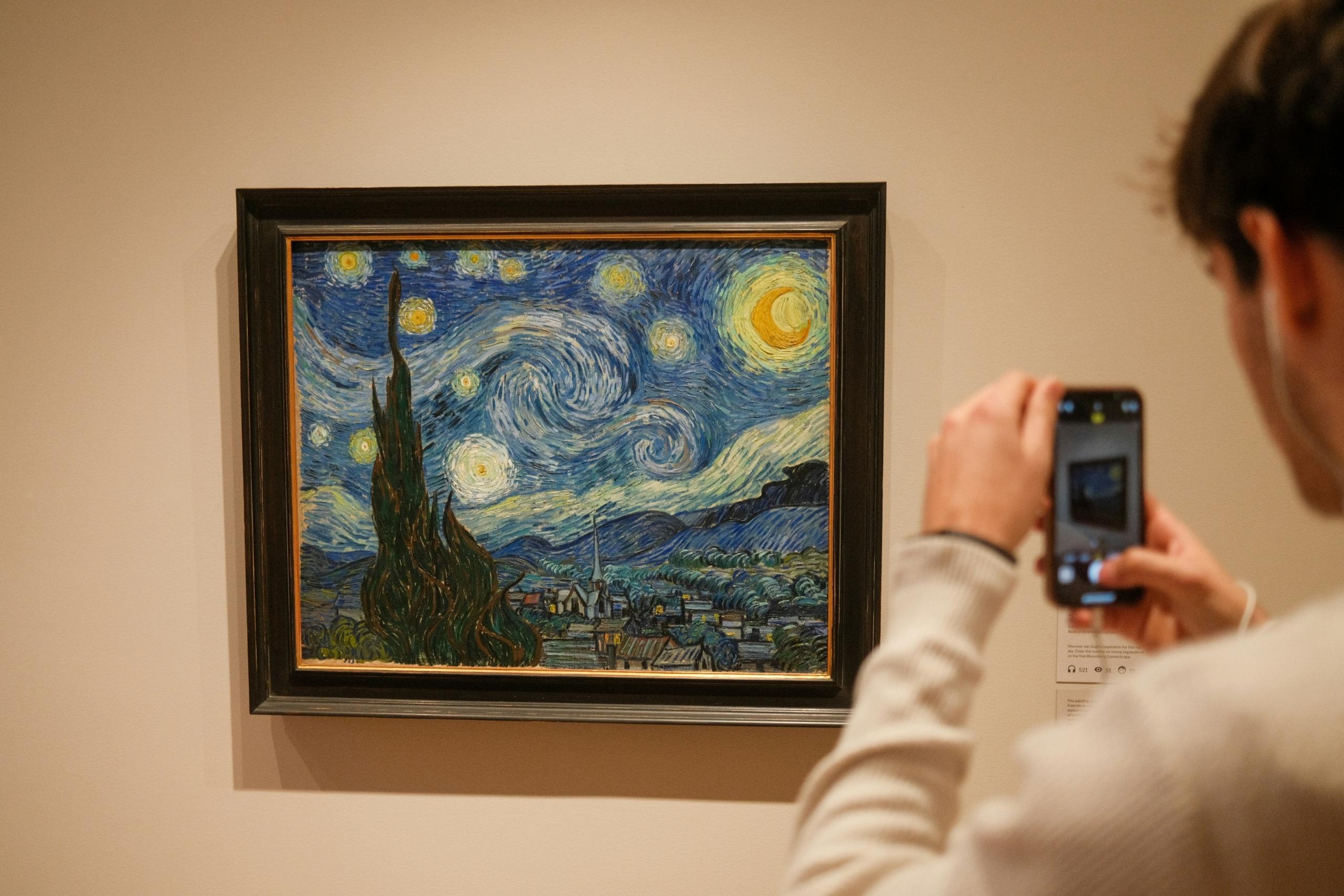 persona fotografiando La Noche Estrellada de Van Gogh