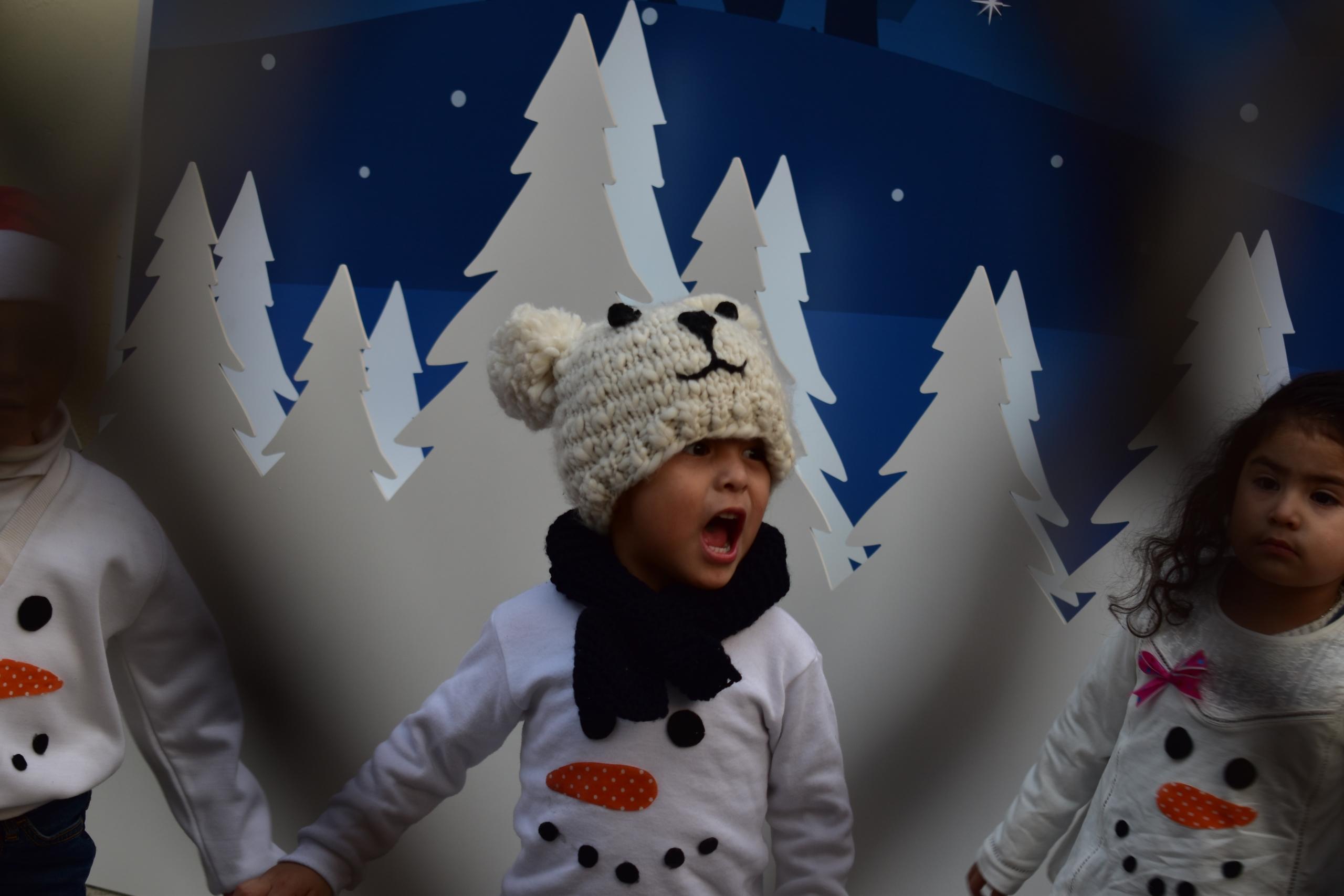 niño cantando con un escenario invernal de fondo