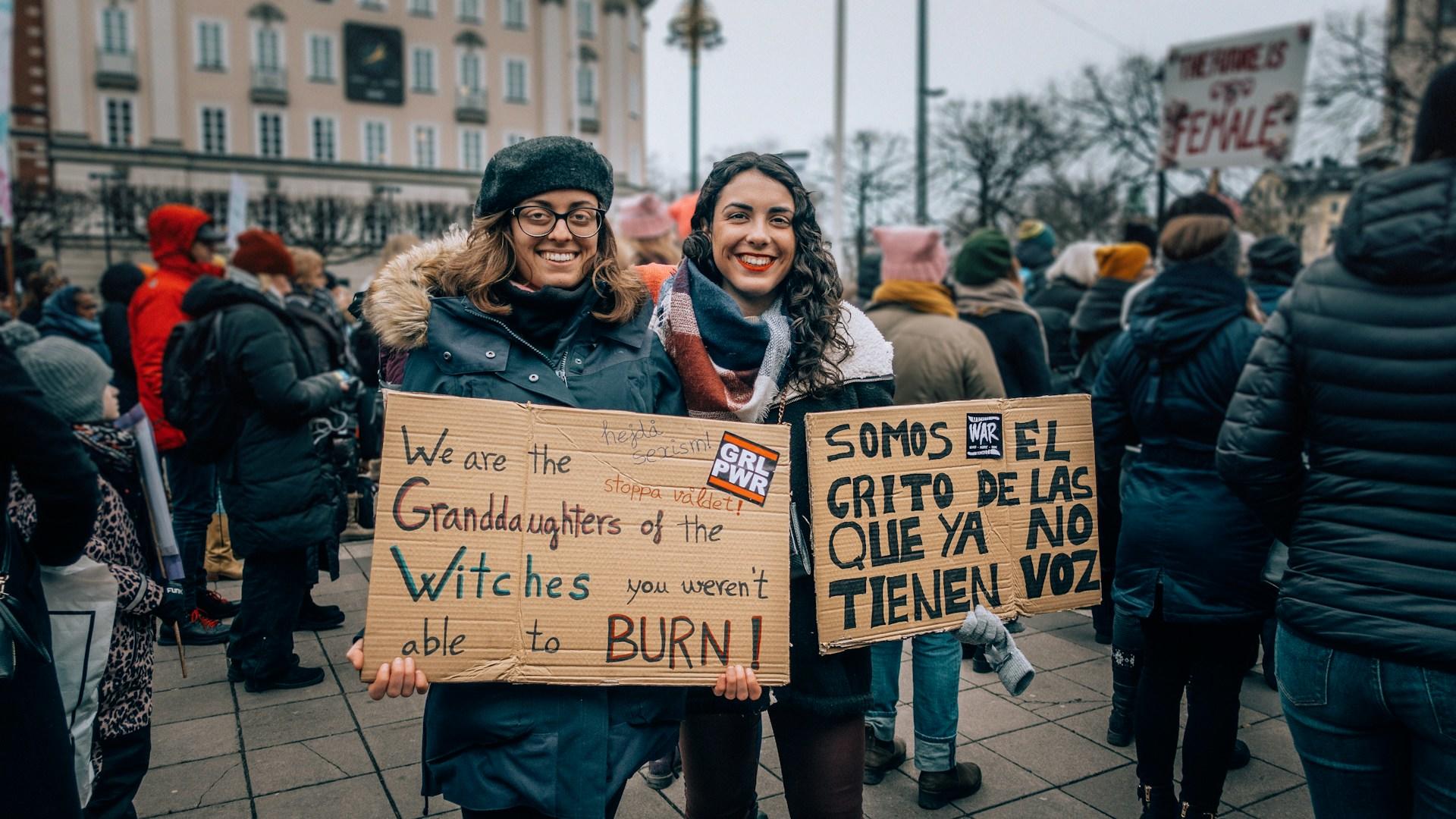 dos mujeres sosteniendo carteles de protesta