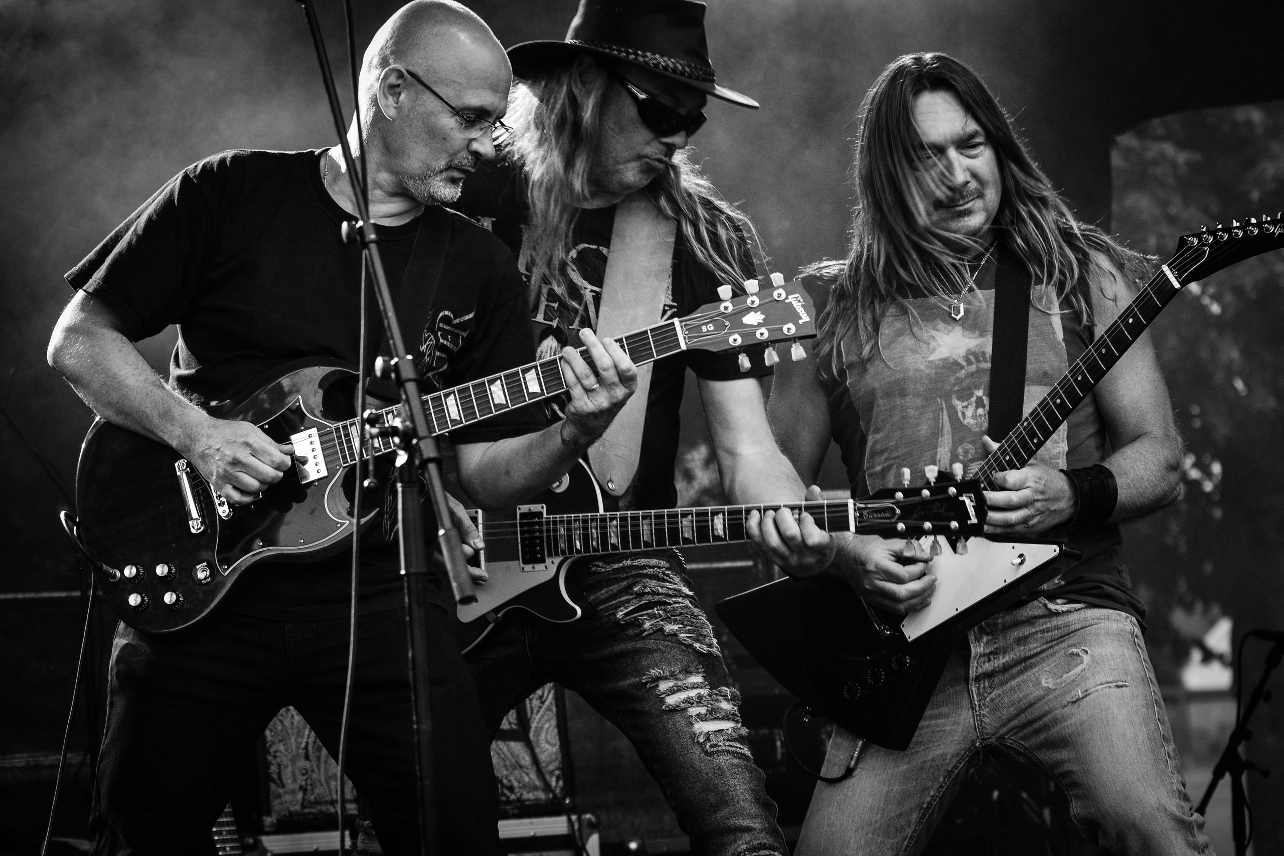 tres musicos tocando la guitarra y el bajo