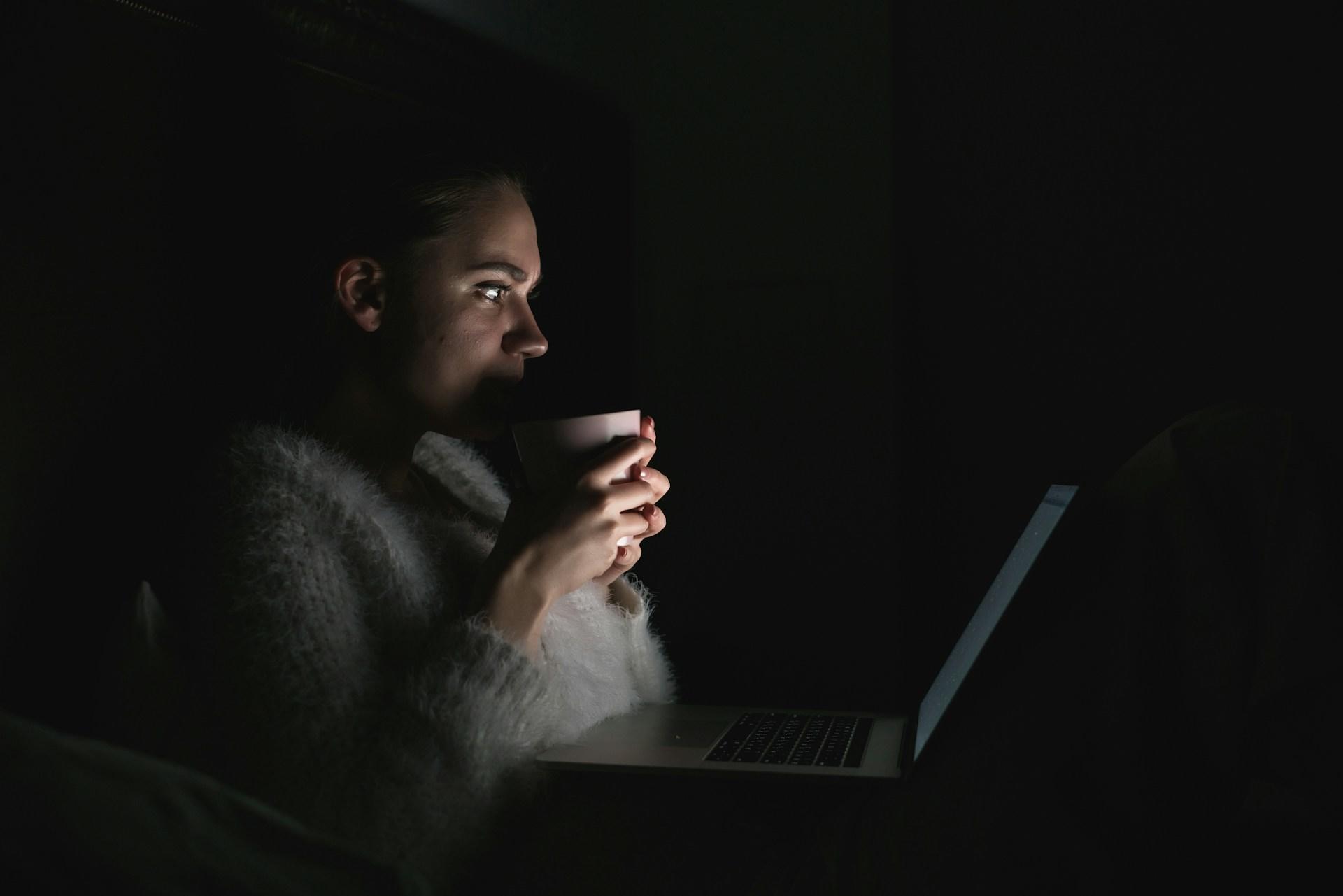 Chica usando la computadora y tomando cafe