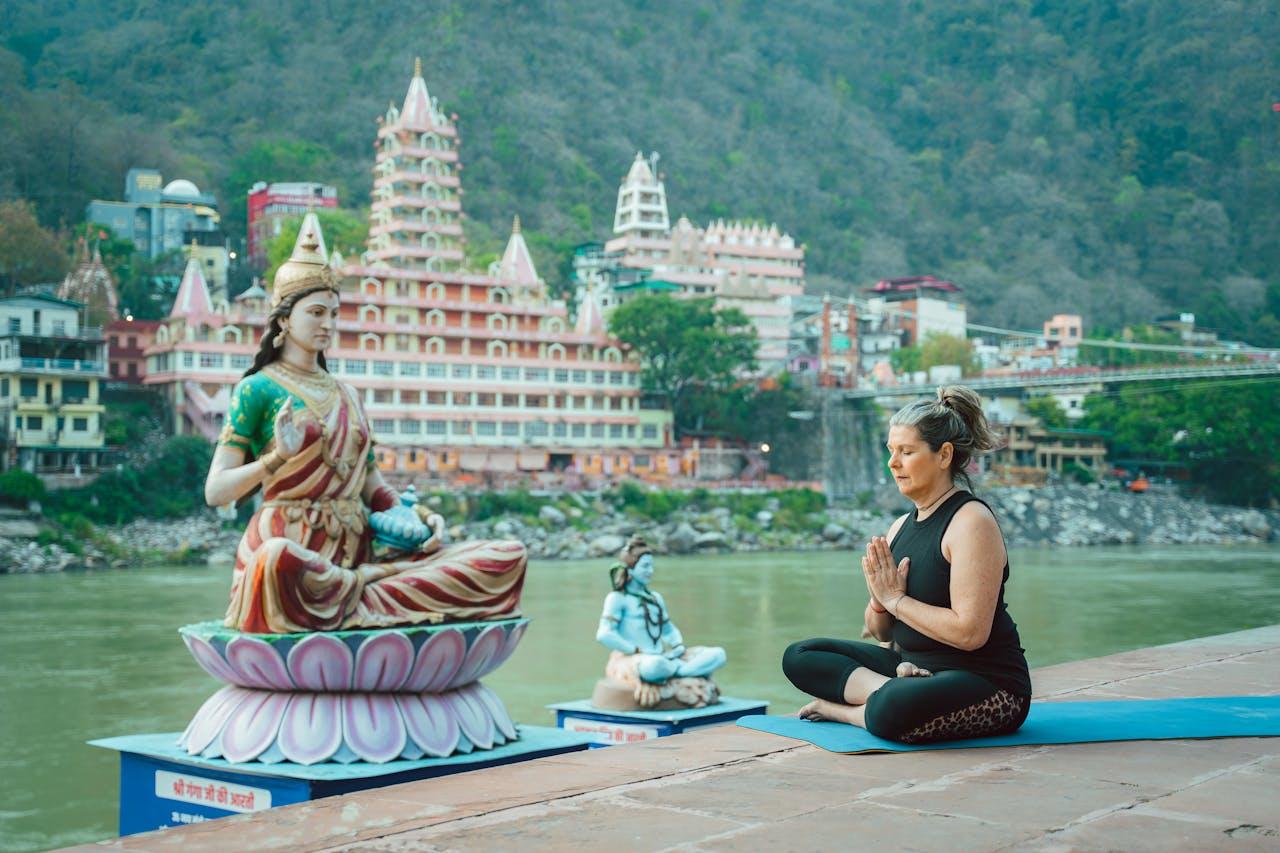 persona meditando frente a estatua de diosa hindu.