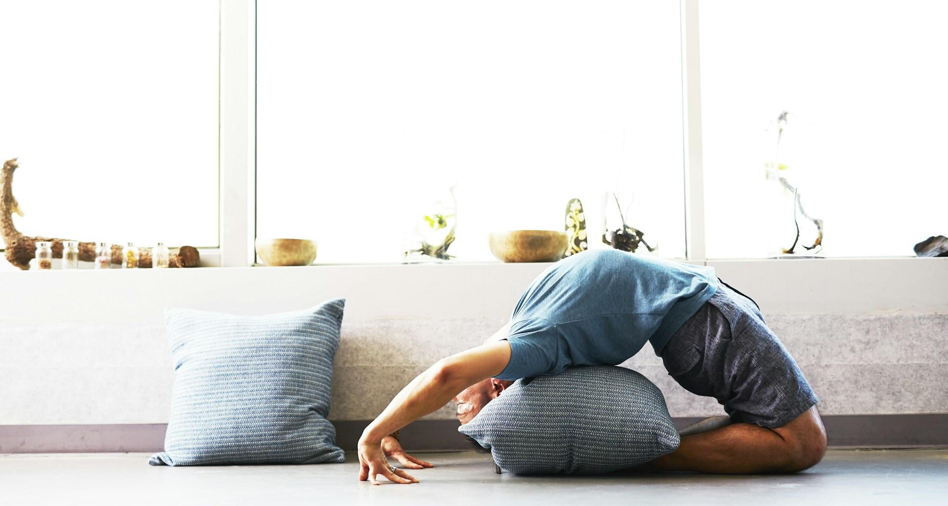 principiante practicando postura de yoga con almohada