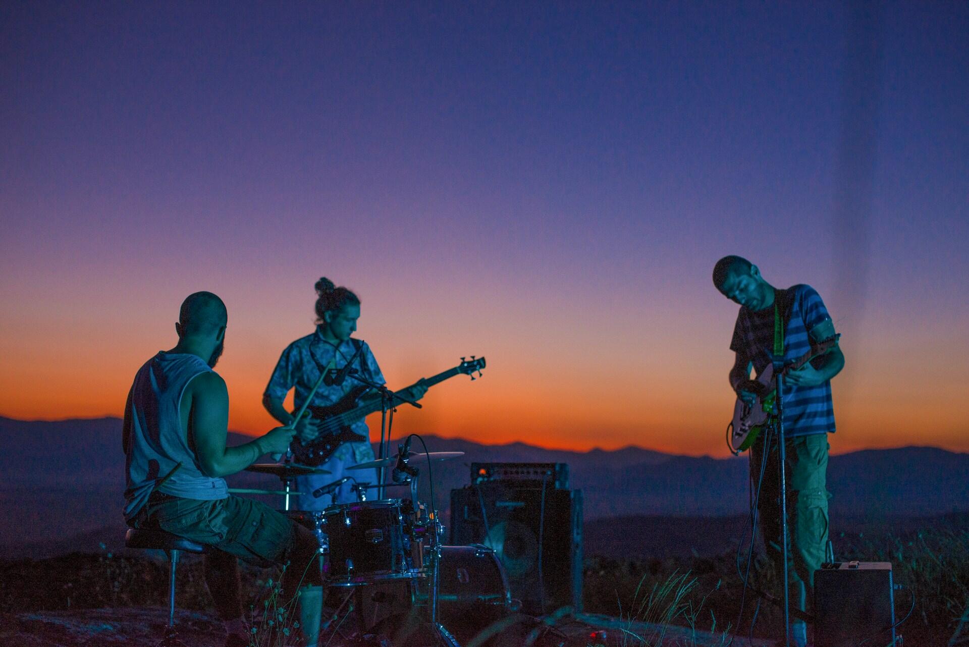 personas de una banda tocando en el atardecer