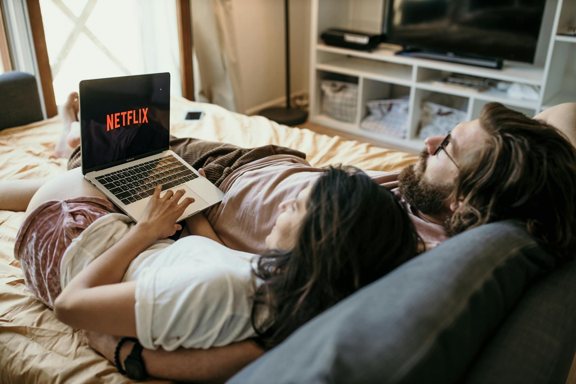 pareja cama computadora netflix