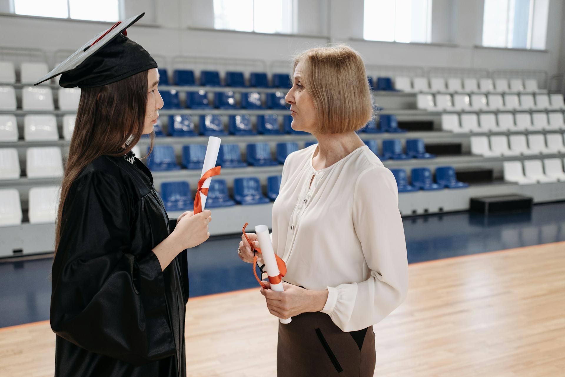 dos mujeres estudiante vestida de graduación diploma