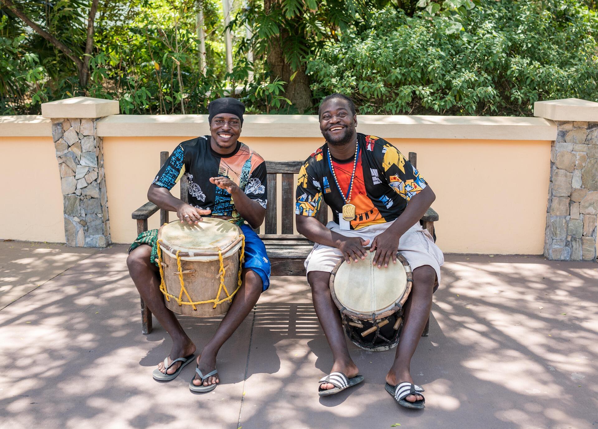 dos hombres tocando el tambor en la calle sonrisas