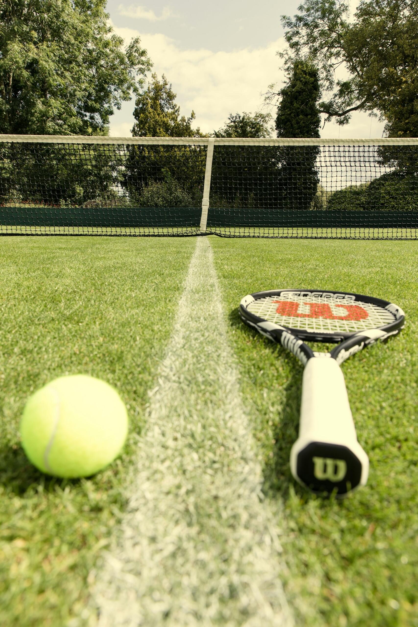 raqueta en pasto de tenis