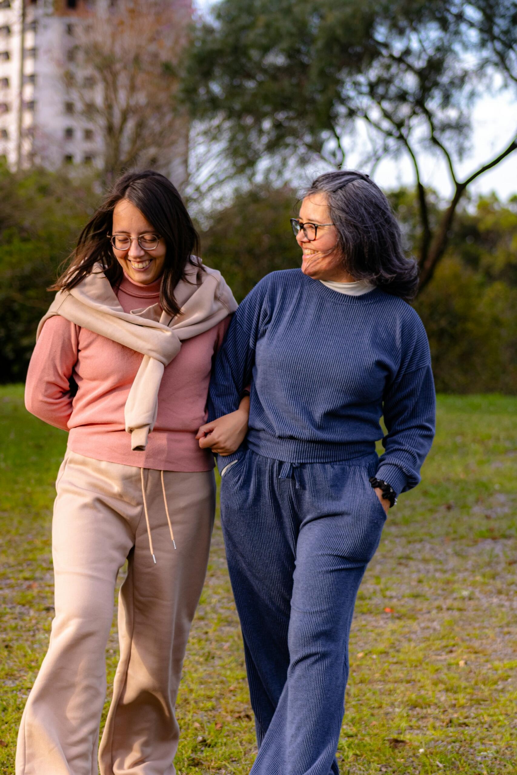 Foto de Samuell Morgenstern en Unsplash. Dos mujeres sonríen mientras caminan y conversan en un parque.