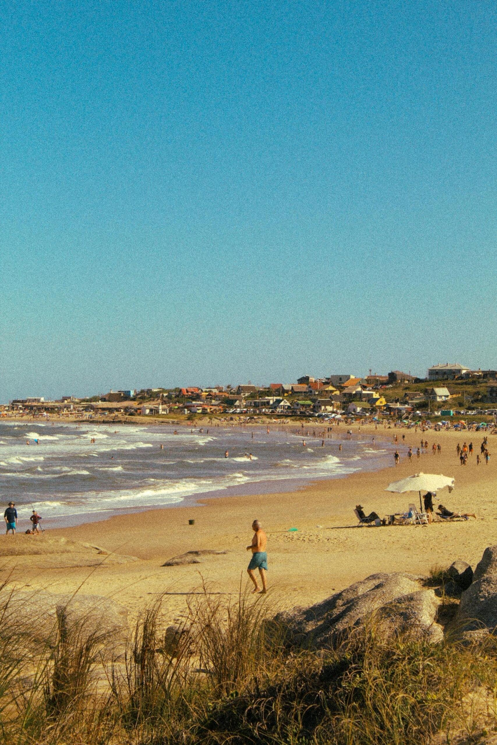 Playa de Punta del Diablo en Rocha, Uruguay. Turistas disfrutando del mar, representando la importancia del sector turístico para la economía local. Fotografía de Gaspar Liddle.
