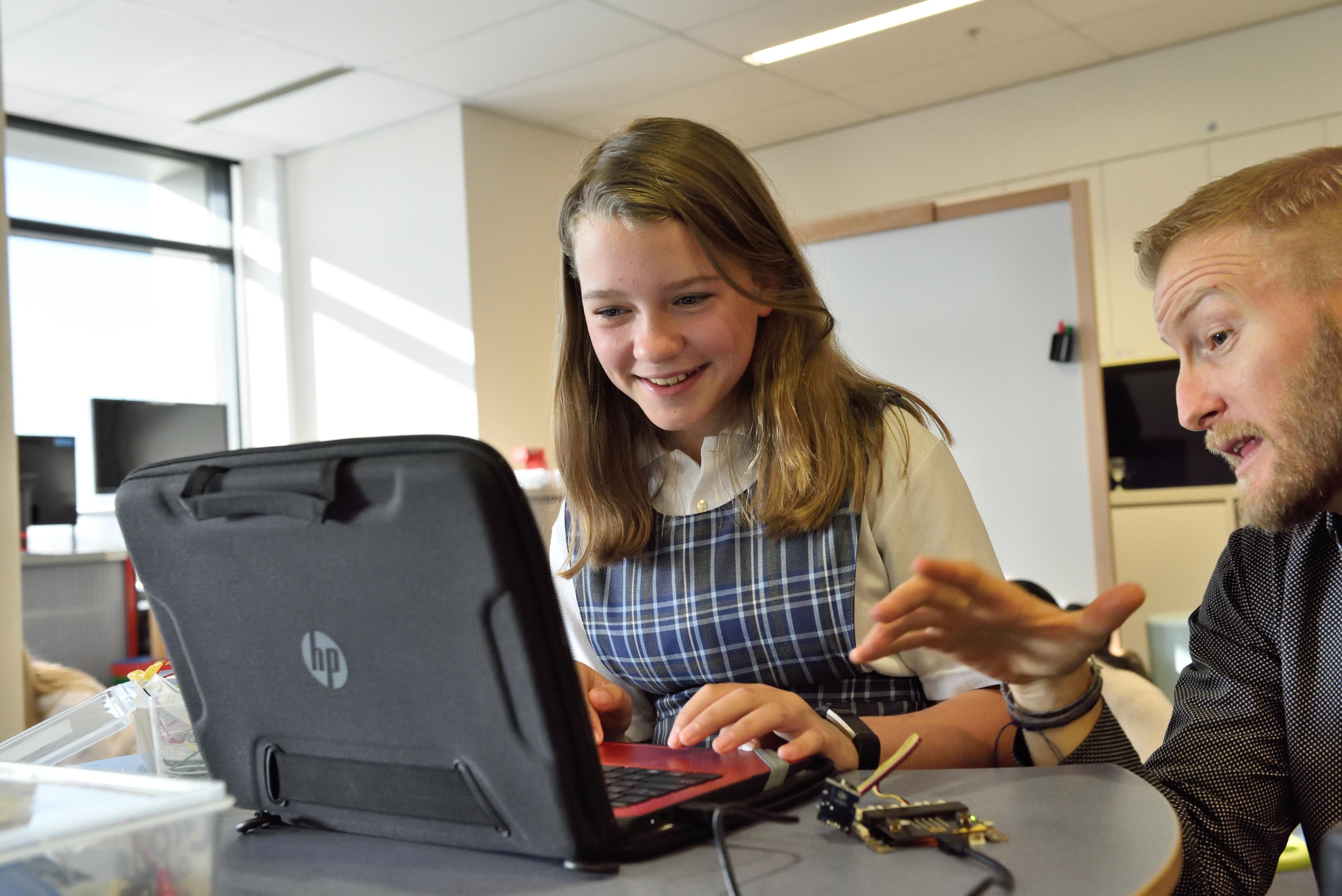 teaching helping girl with laptop