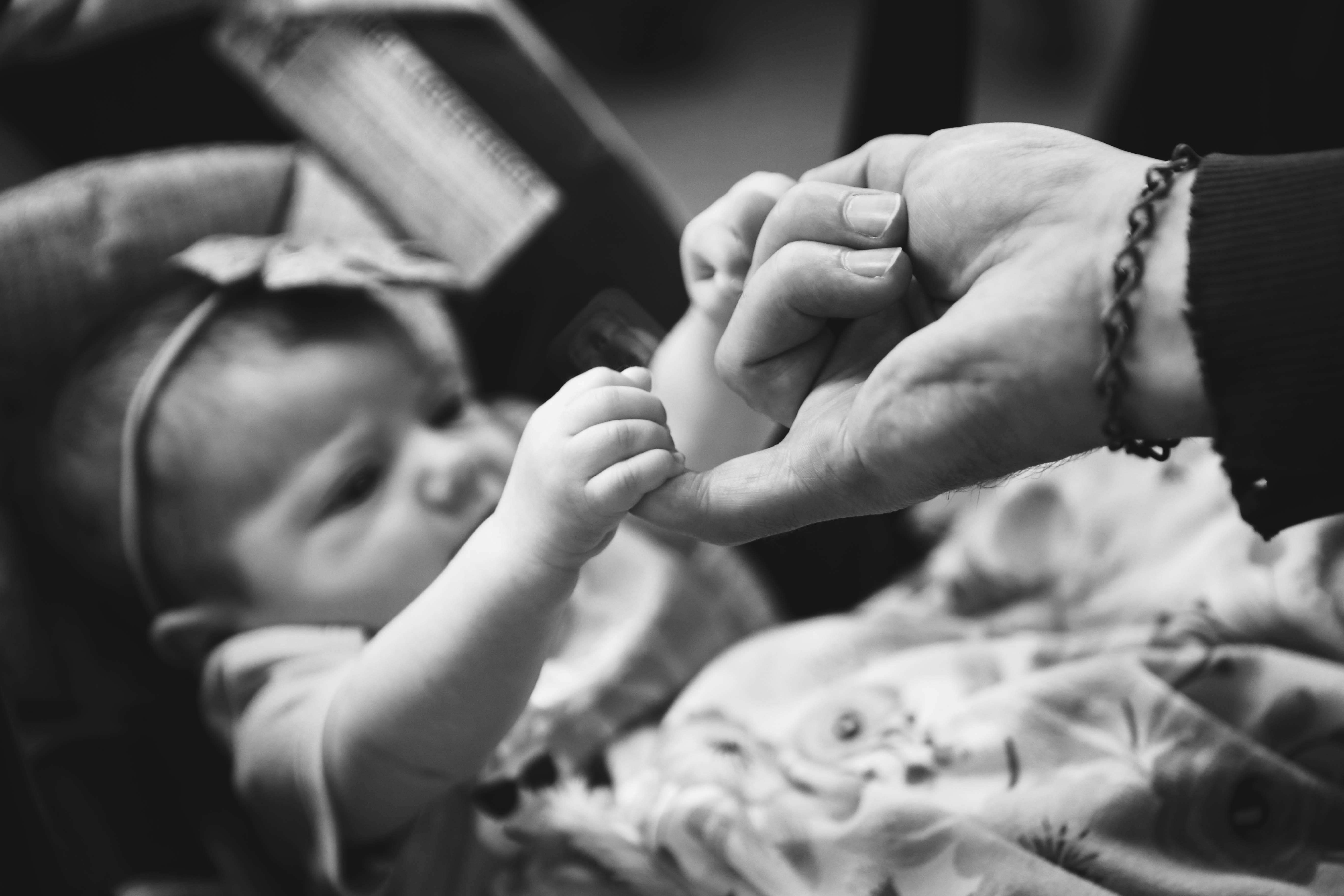 baby girl reaching to touch hand