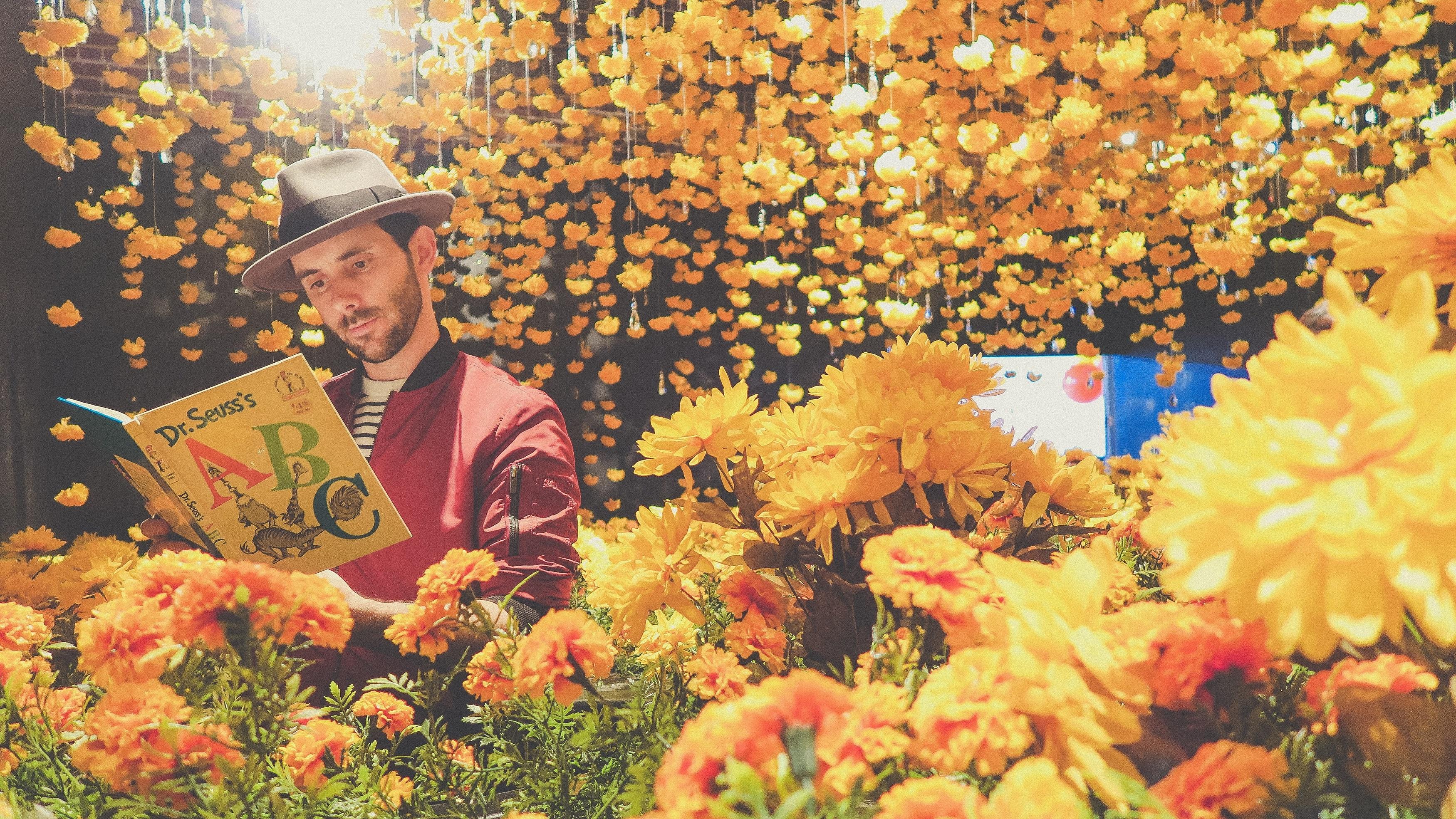 man reading amongst flowers