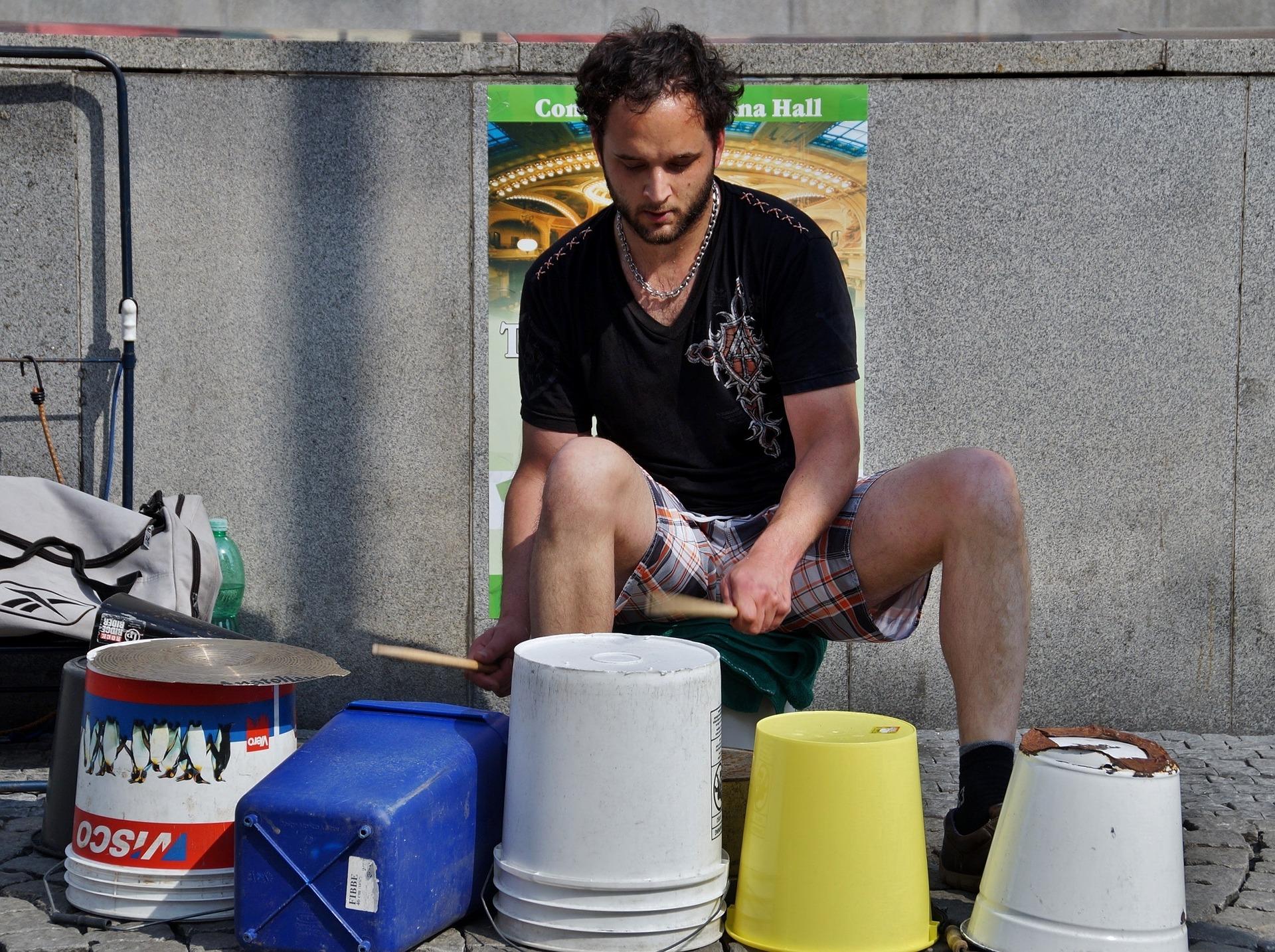 Man drumming on upturned buckets