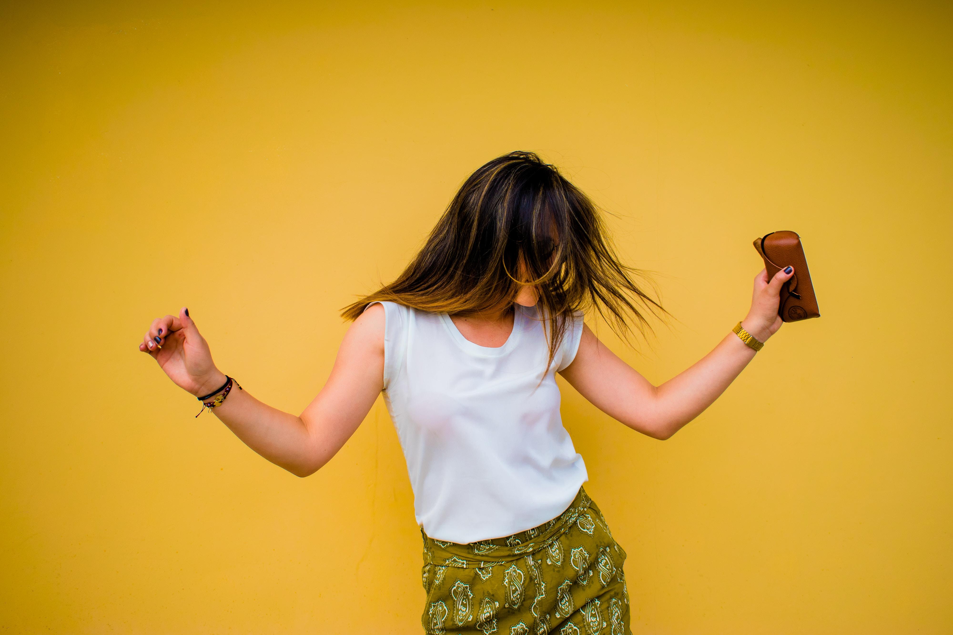 woman dancing in front of yellow wall