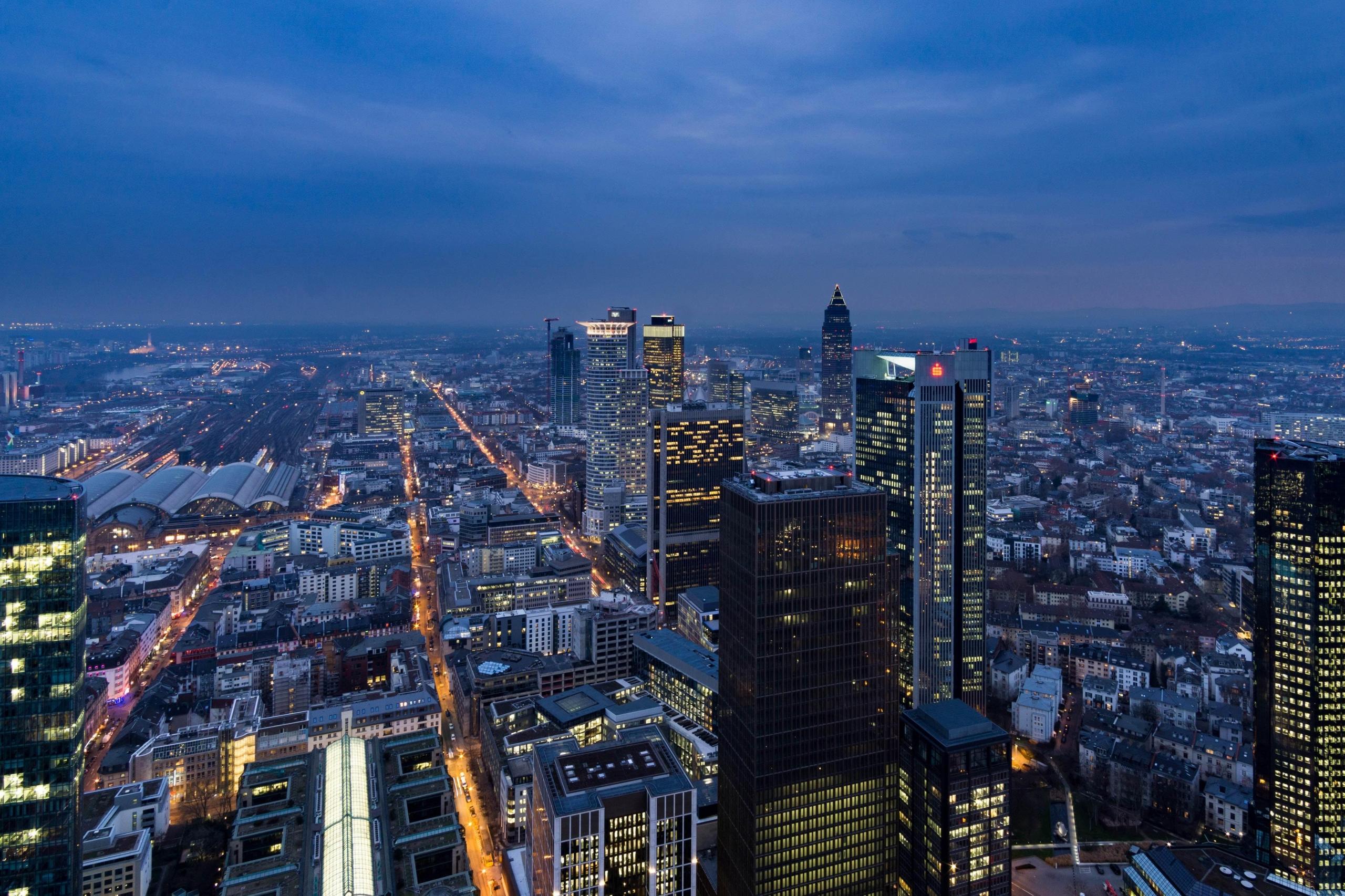 aerial photography of lit up city buildings under blue and white sky