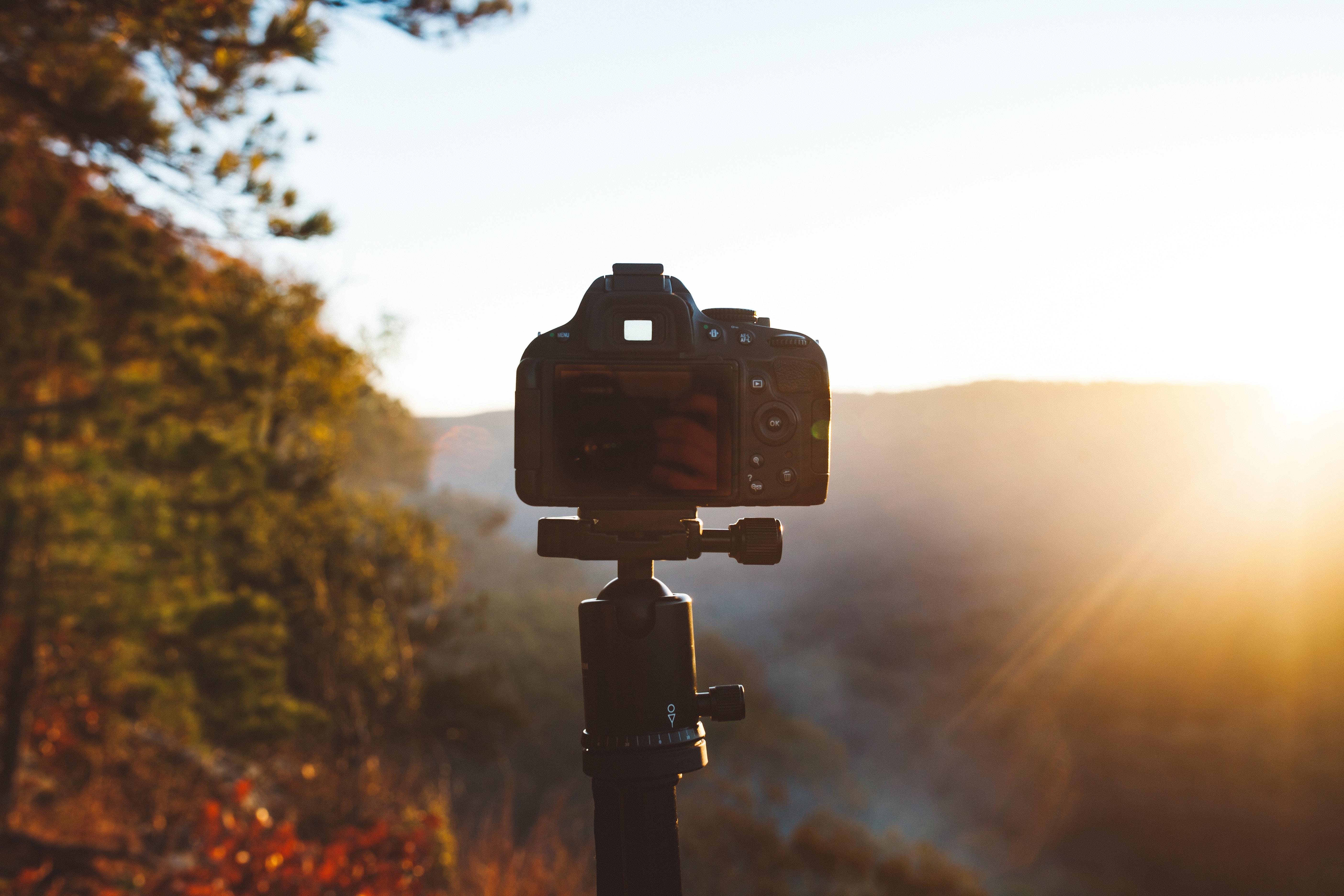 camera set on tripod on a hill at sunrise
