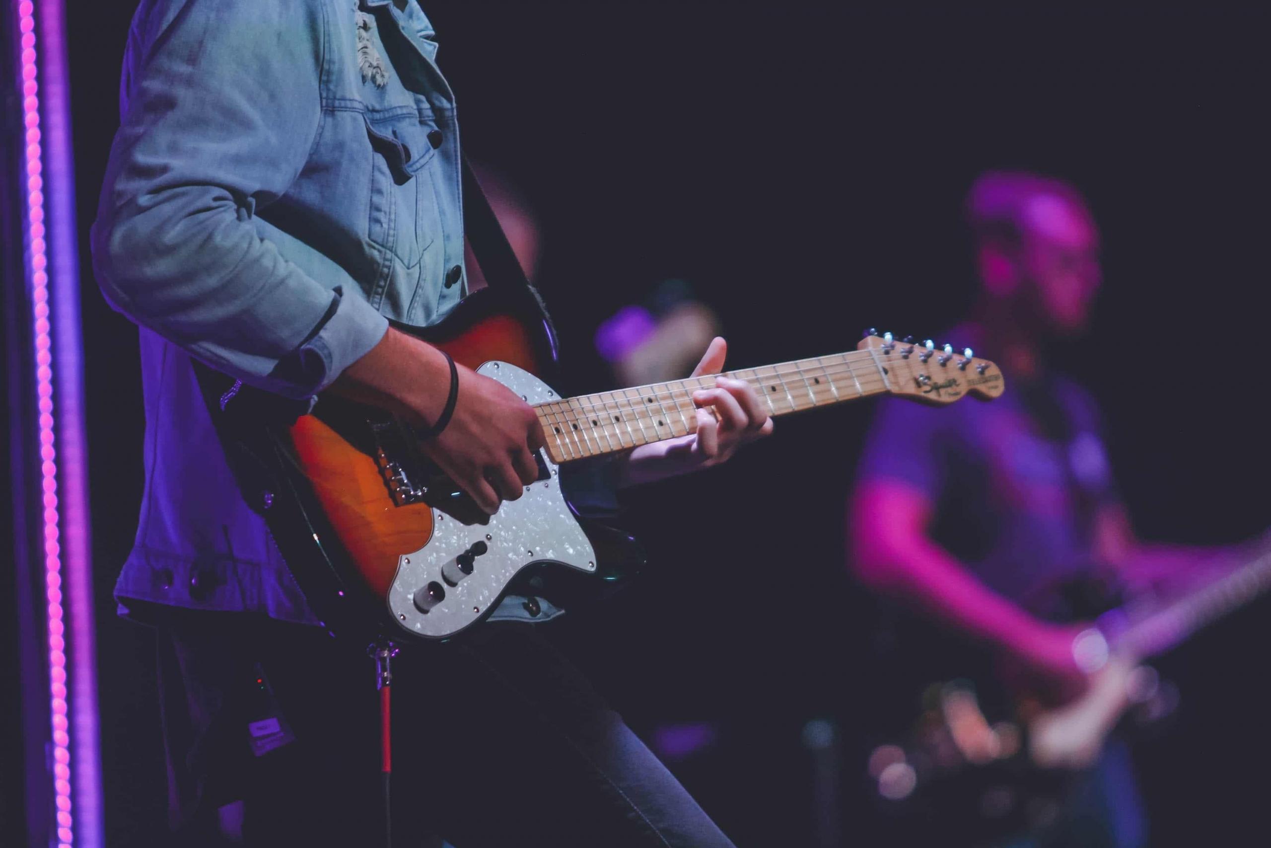 man playing electric guitar on stage