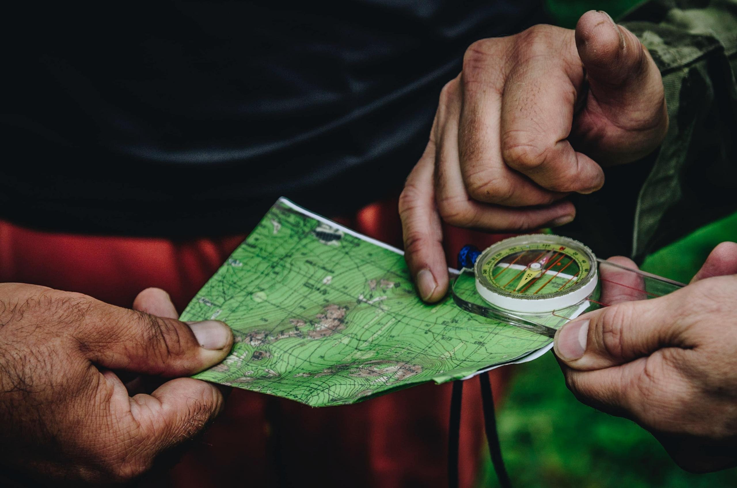 two people reading a map and using a compass