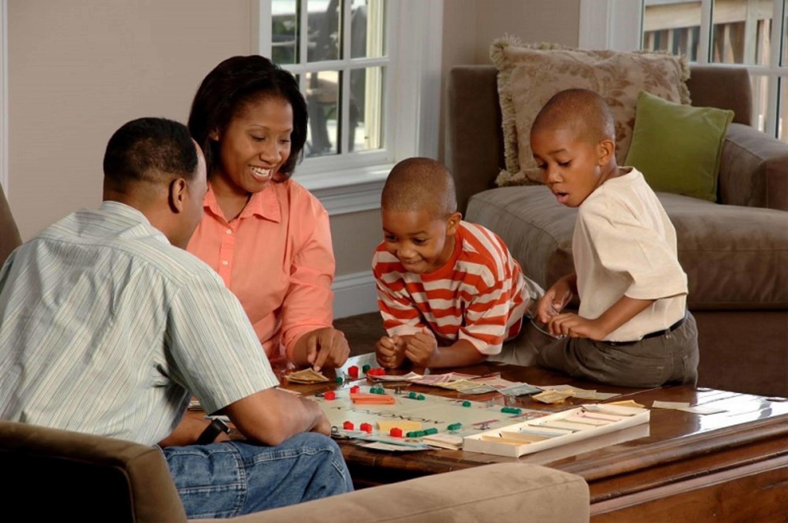 parents and children playing board game