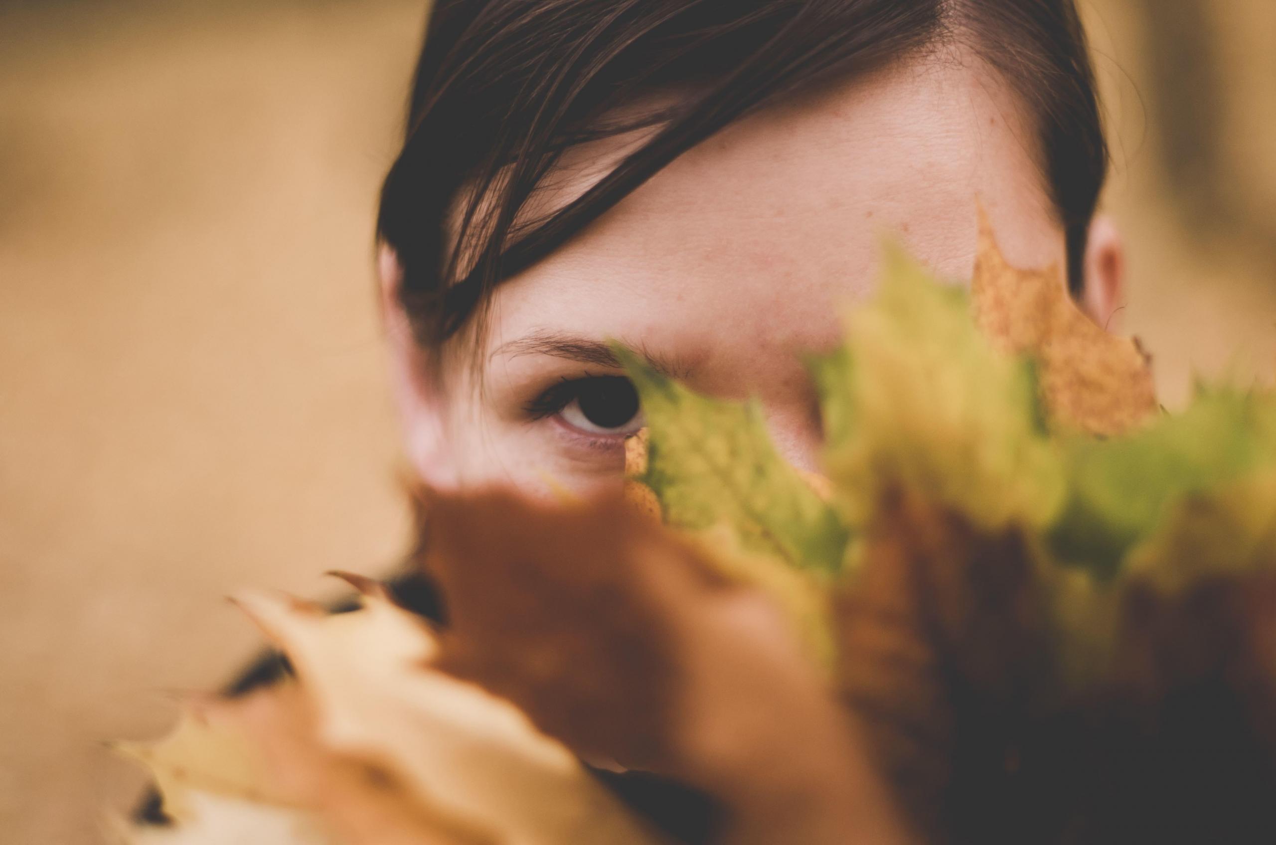 woman hiding behind leaves