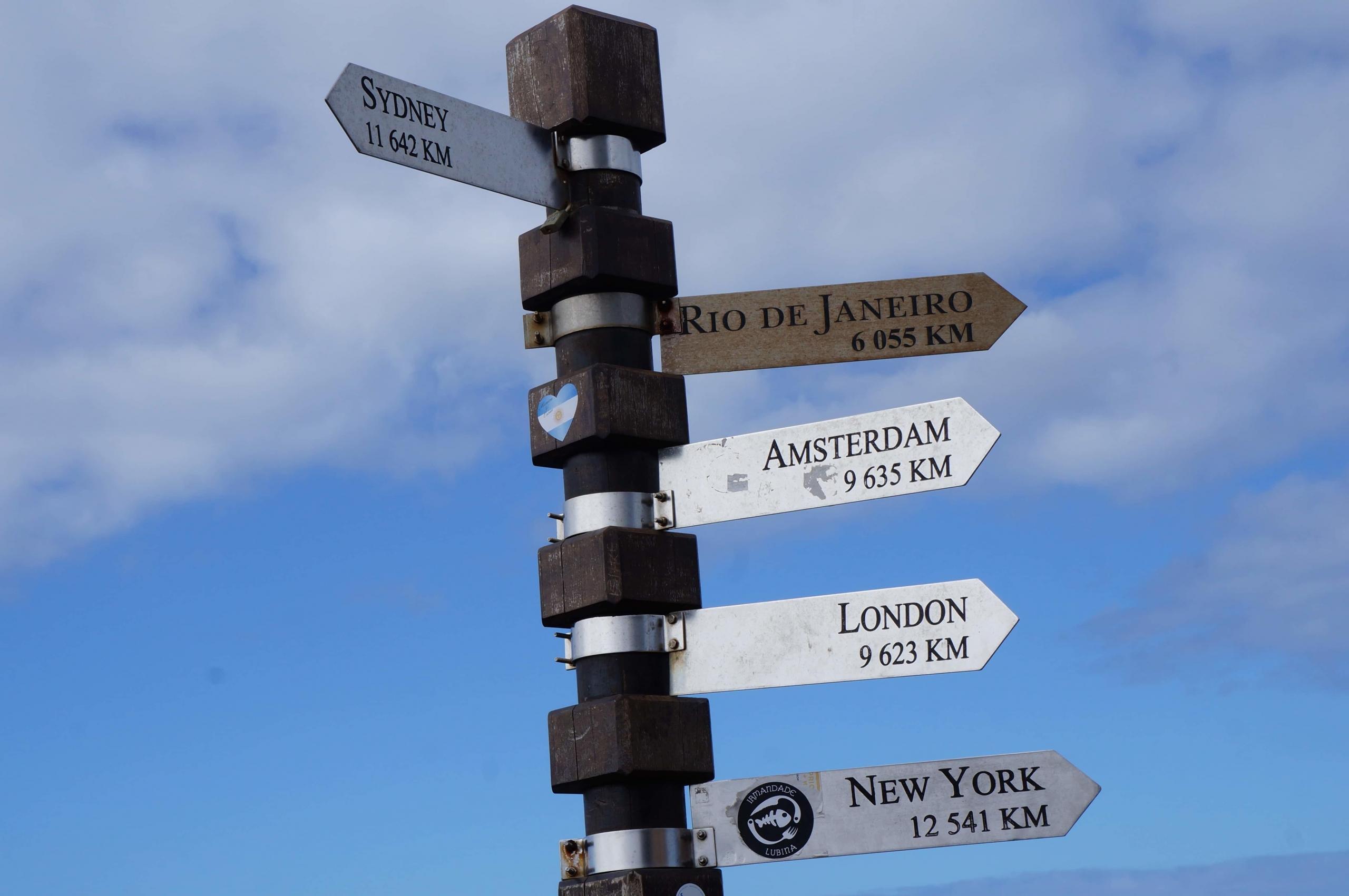 street sign showing distances to different cities