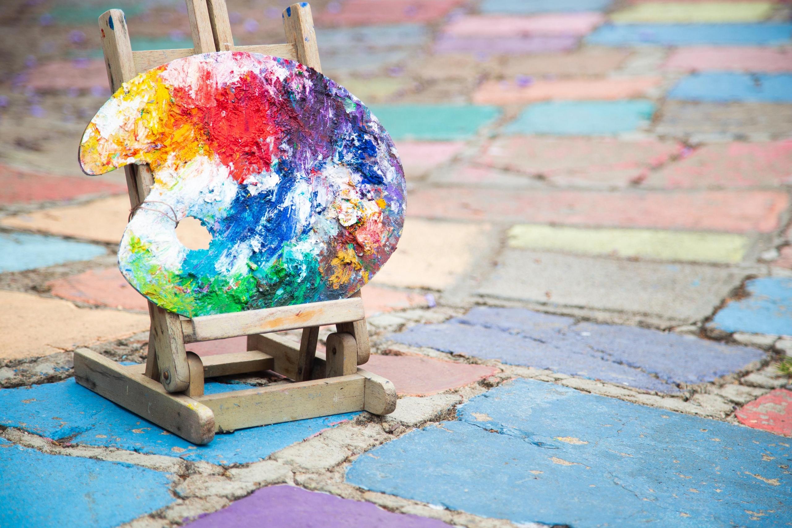 easel and artist's palette on brightly coloured paving