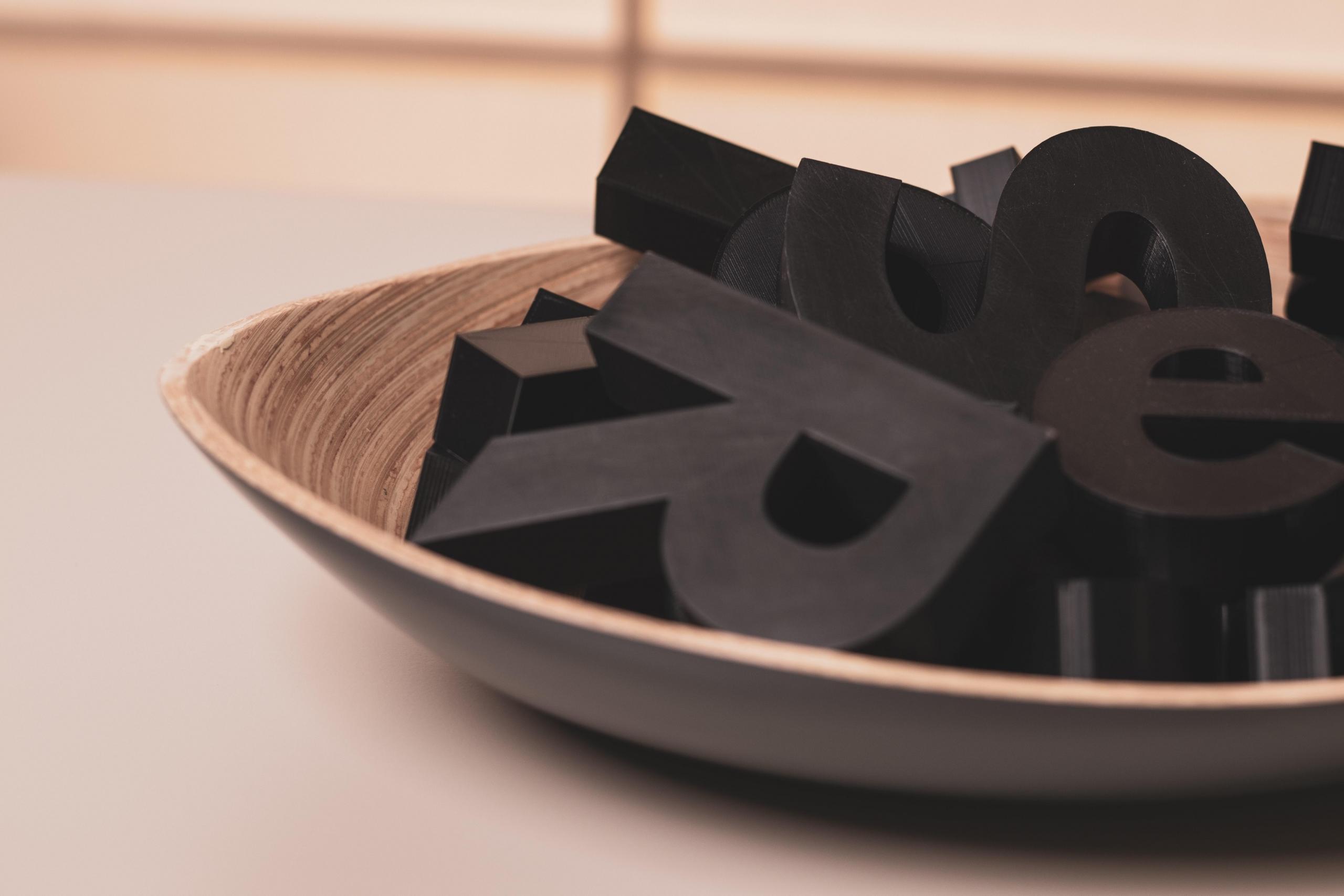 black letters of the alphabet in a bowl