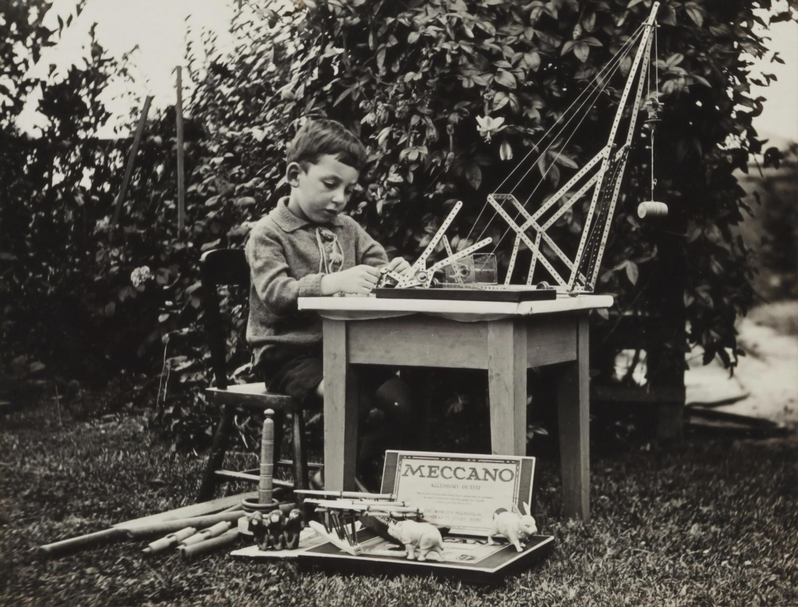 young boy at table making a small model