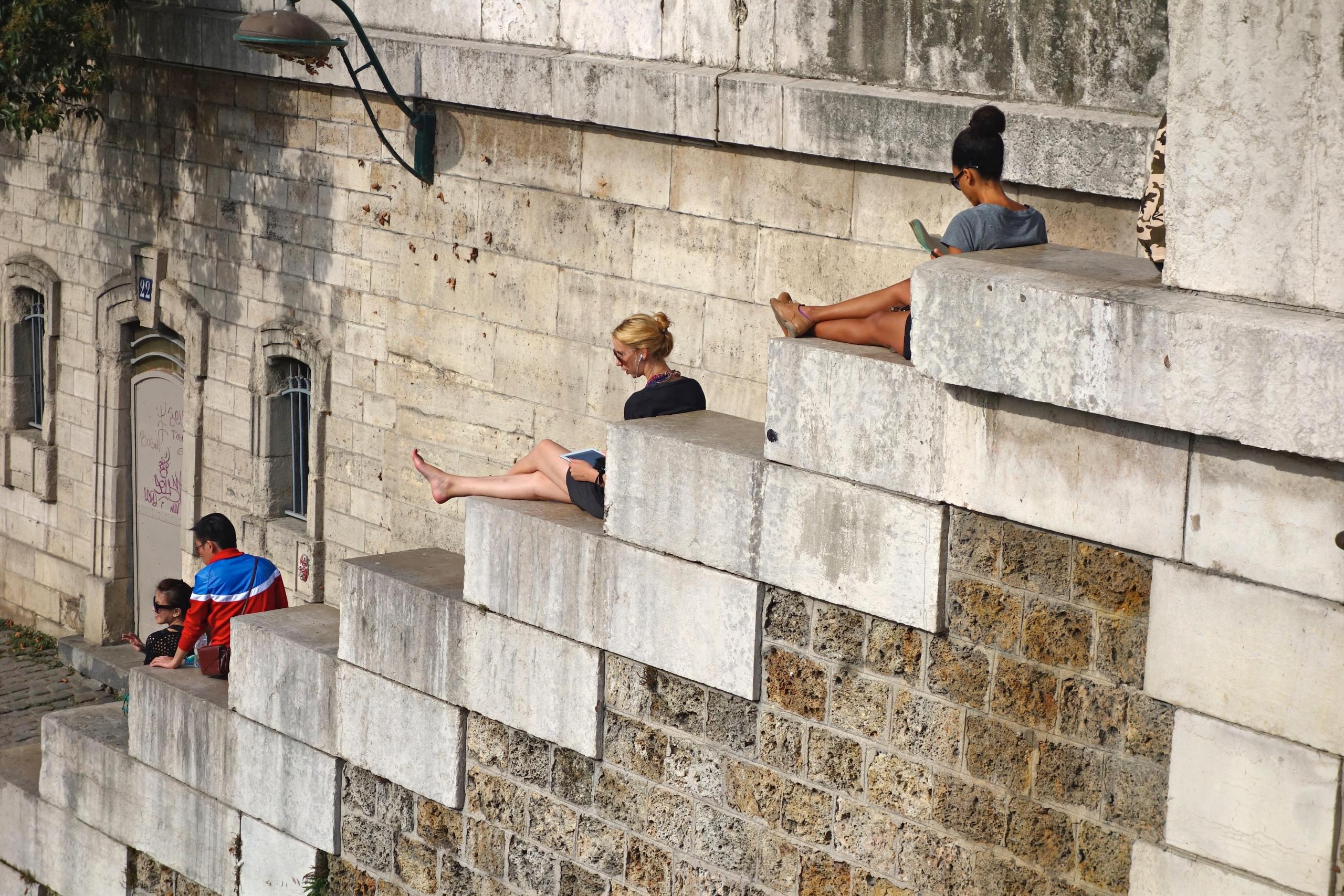 people reading on staircase along the Seine River in Paris