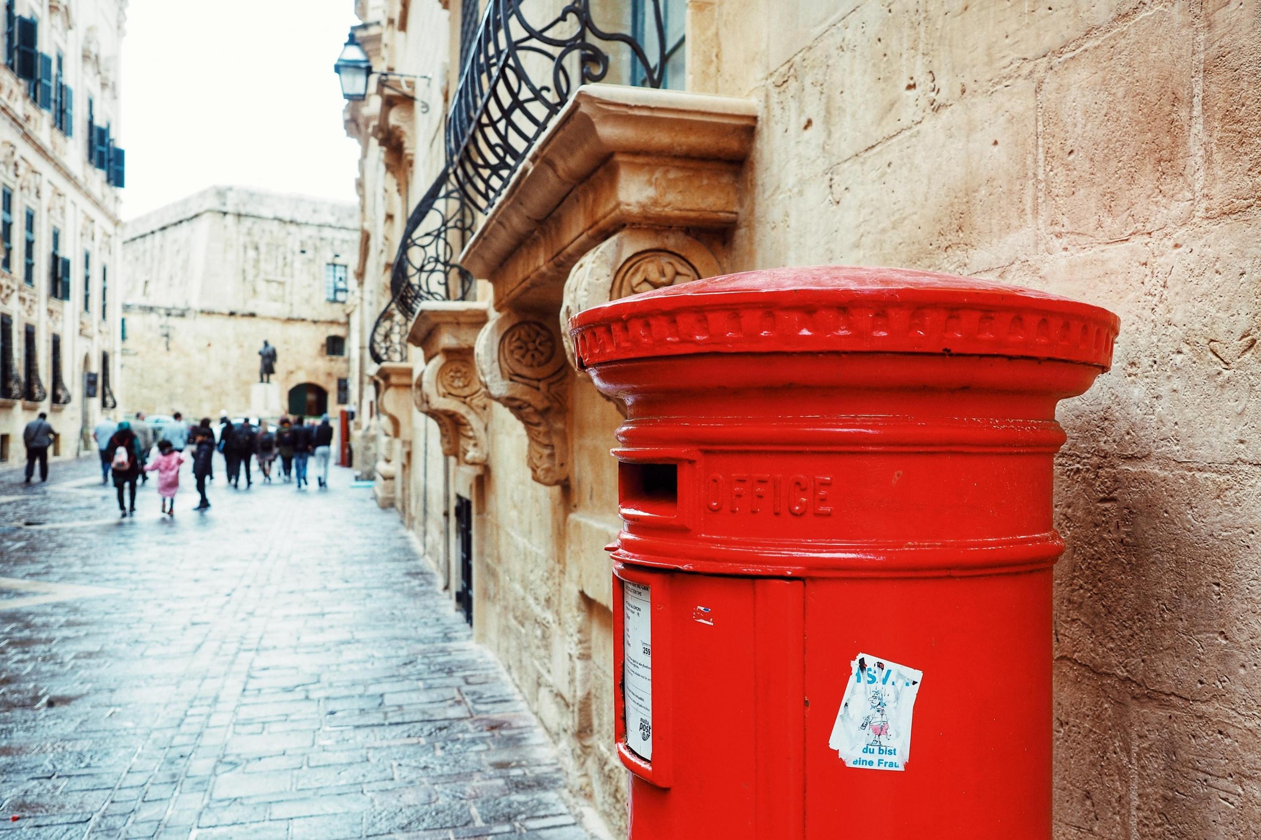 red mailbox near old buildings