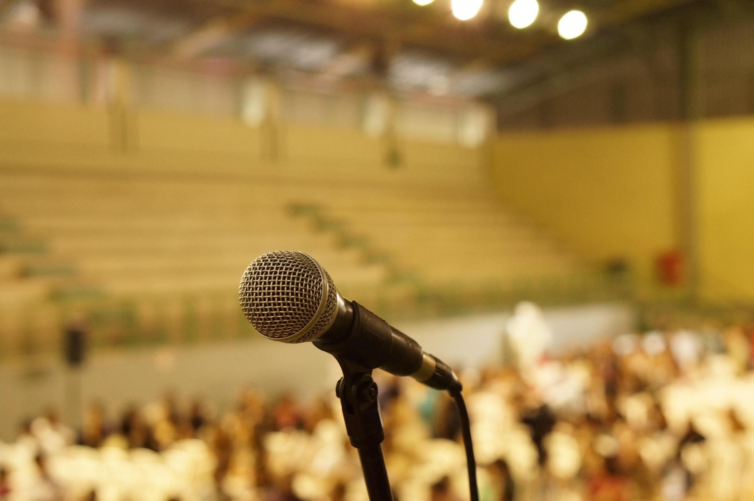 microphone on stage in crowded auditorium