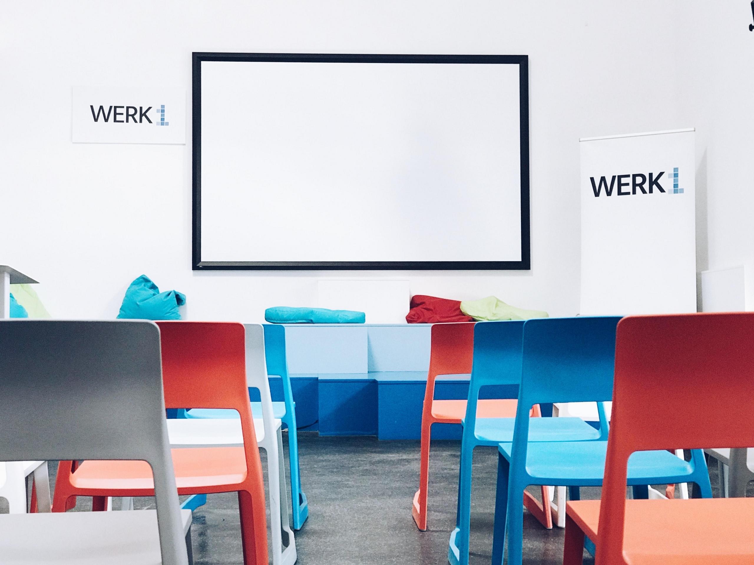 multi-coloured chairs in front of white screen