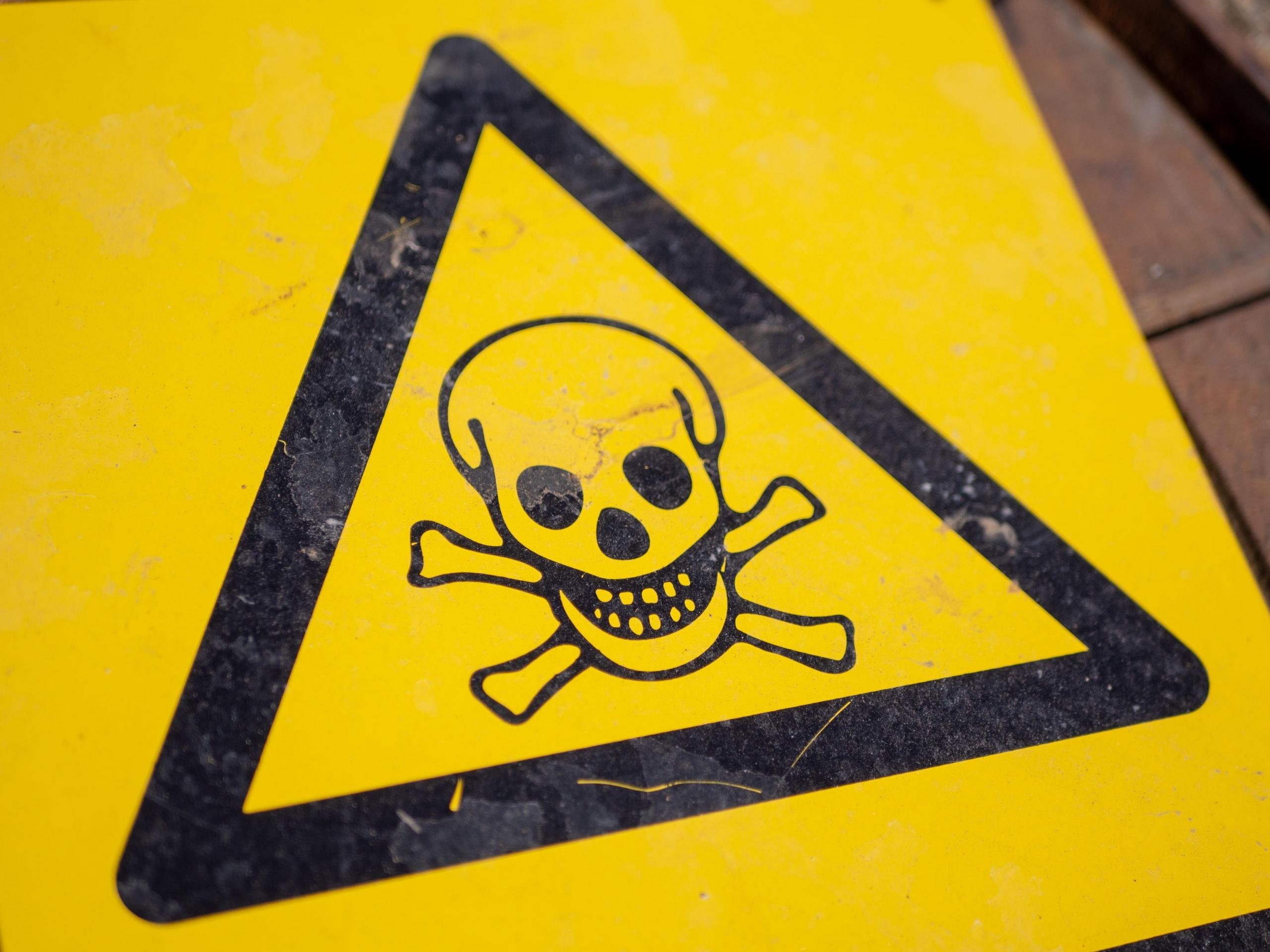 yellow danger sign with skull and crossbones