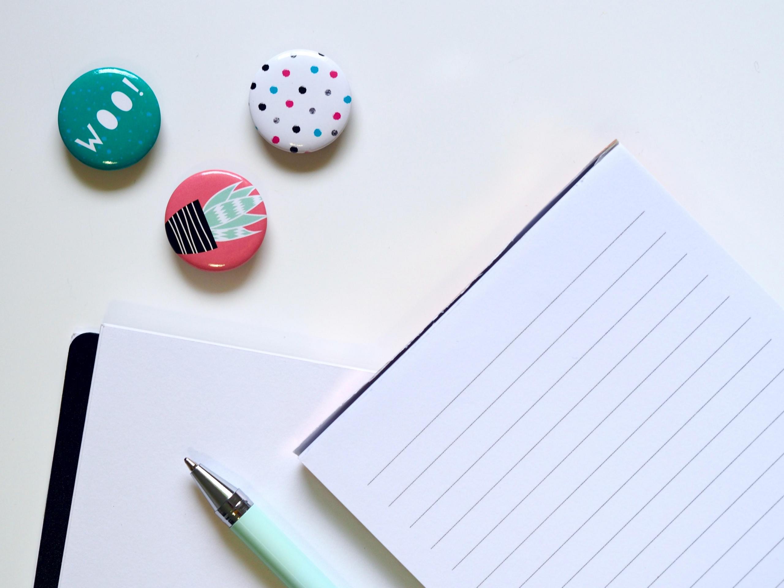 note paper, pen and badges