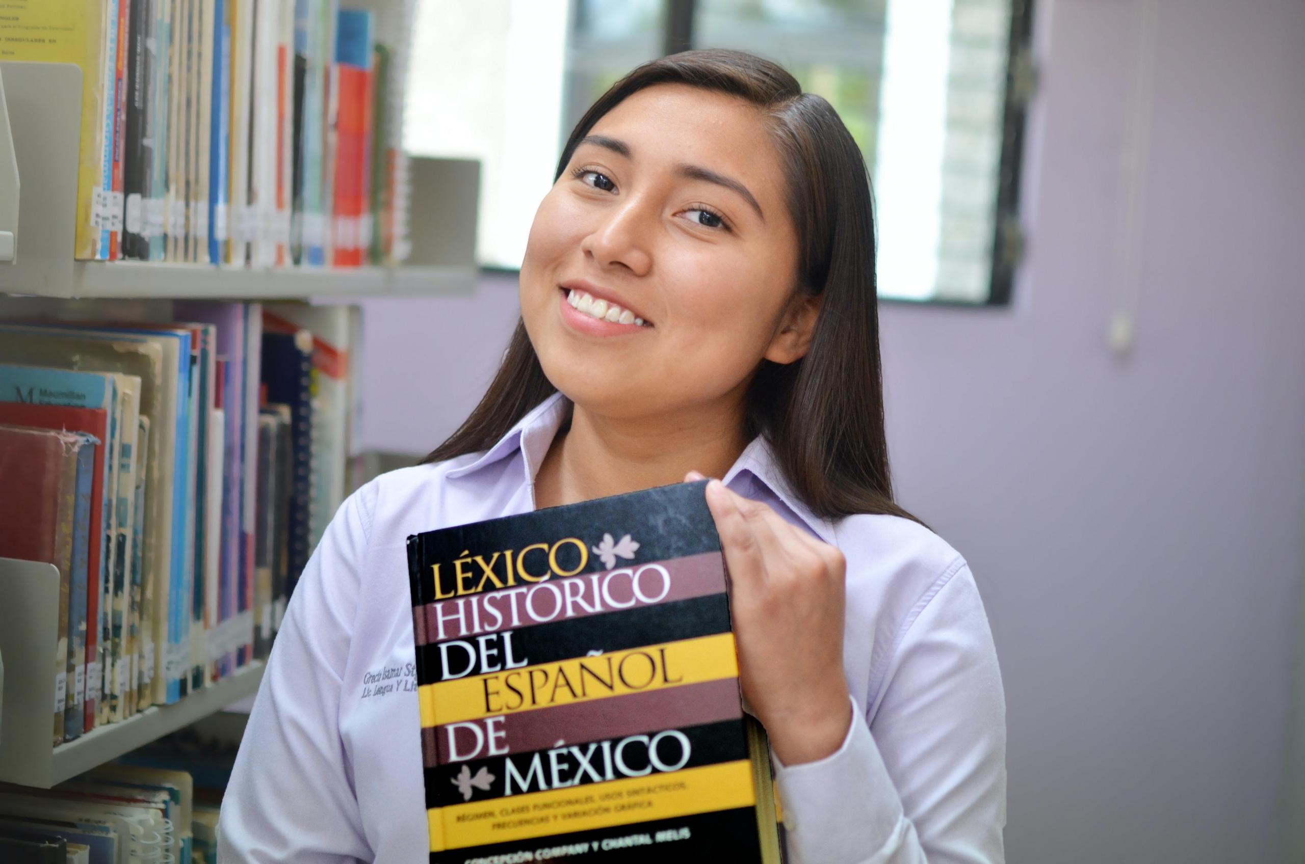 girl holding Spanish book about Mexican Spanish