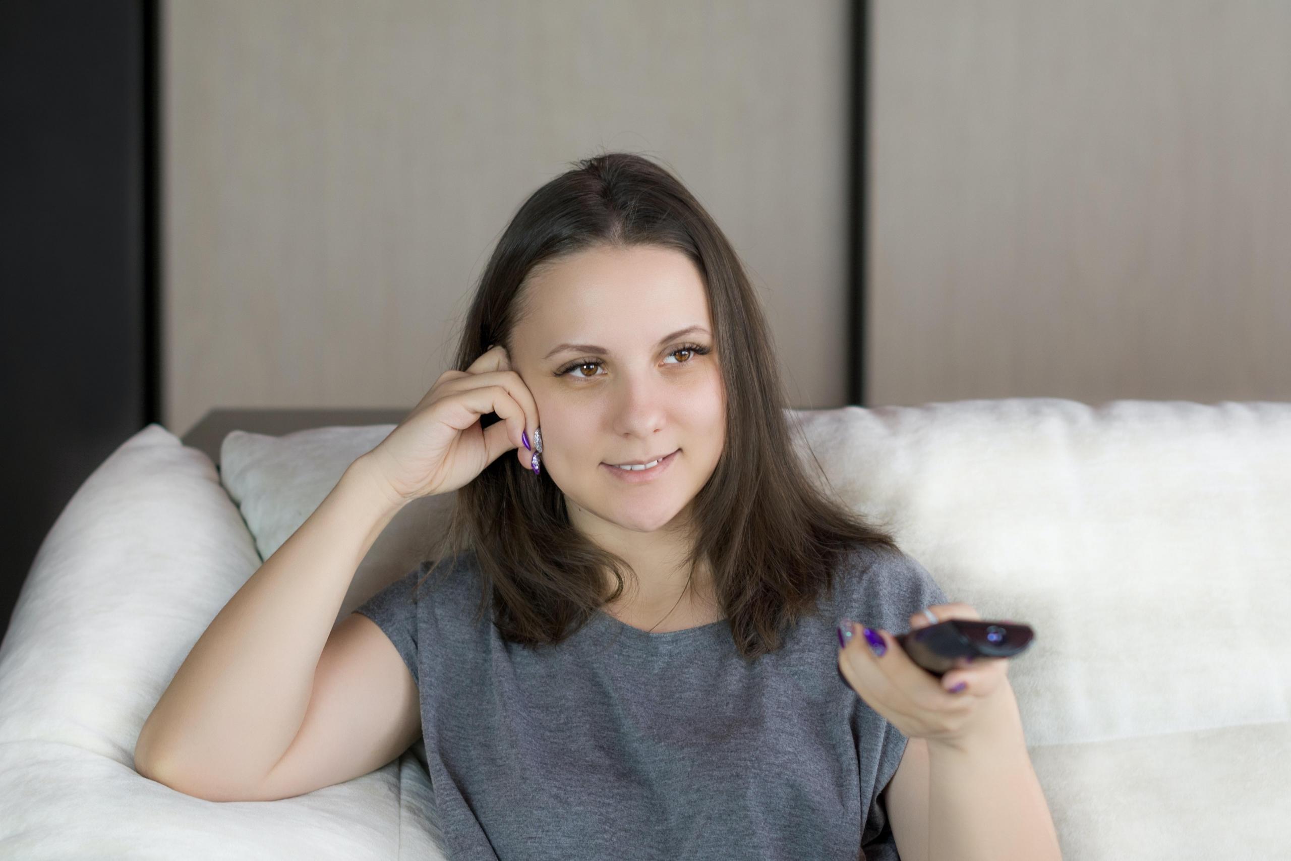 woman watching tv and using remote control
