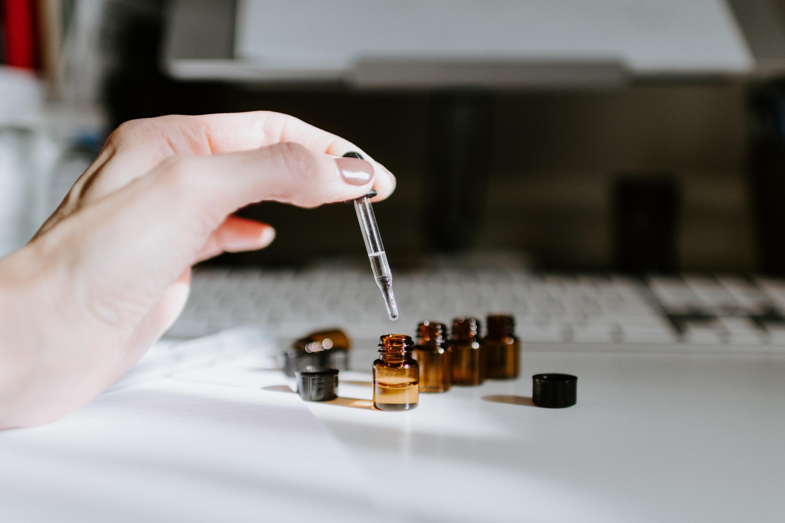 woman using pipette and mini glass vials