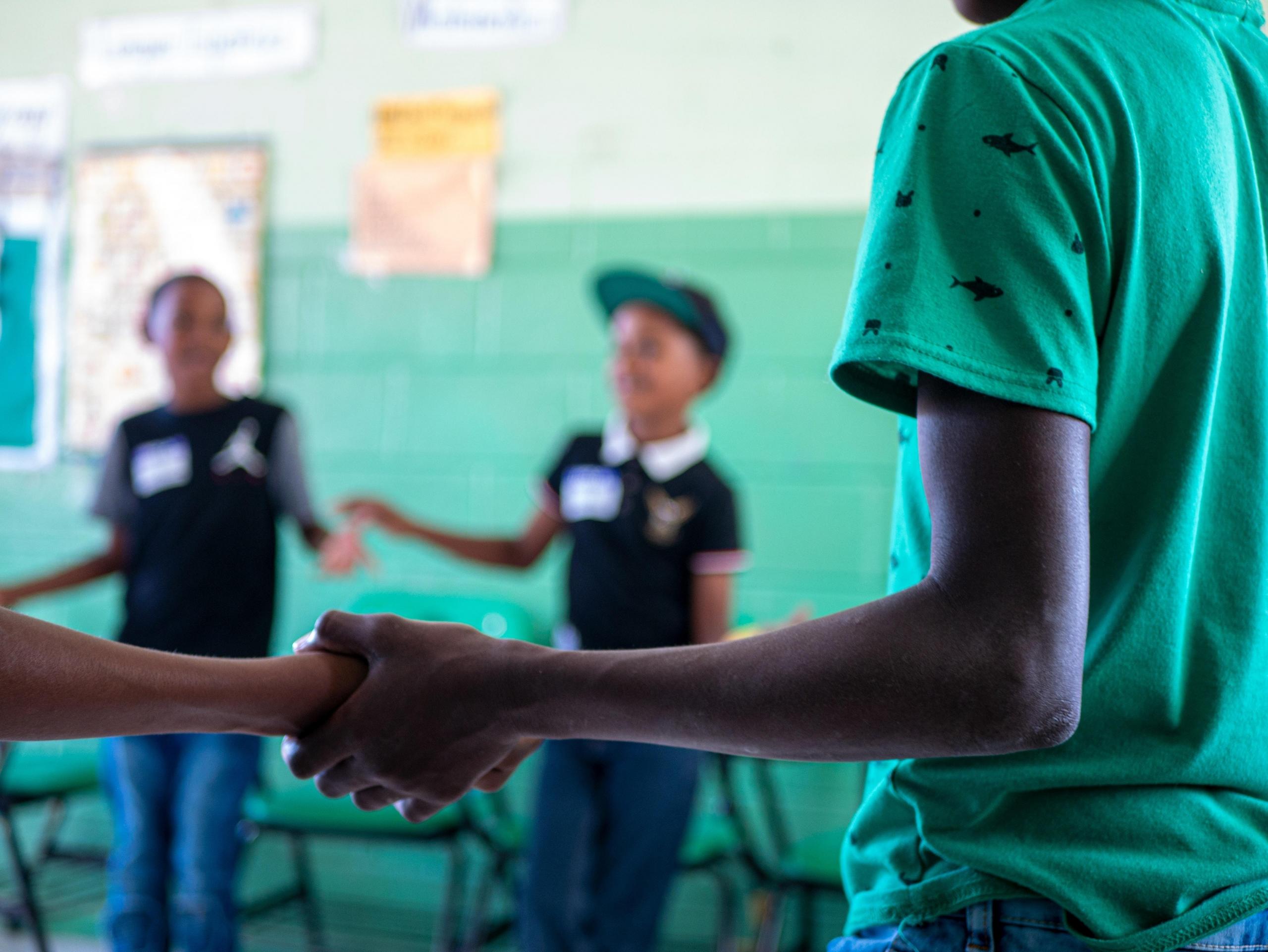 school children holding hands in classroom activity