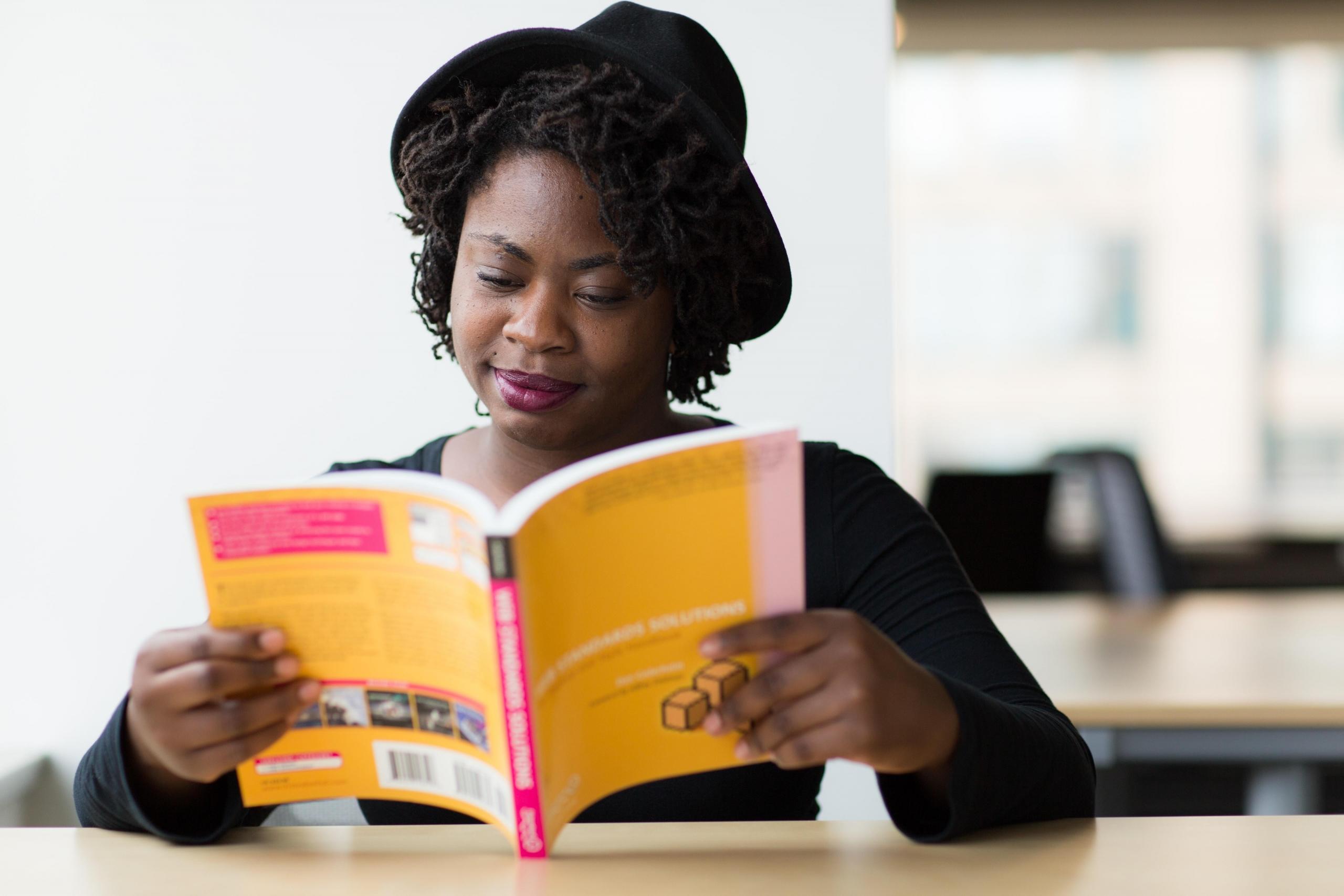 woman reading textbook at desk