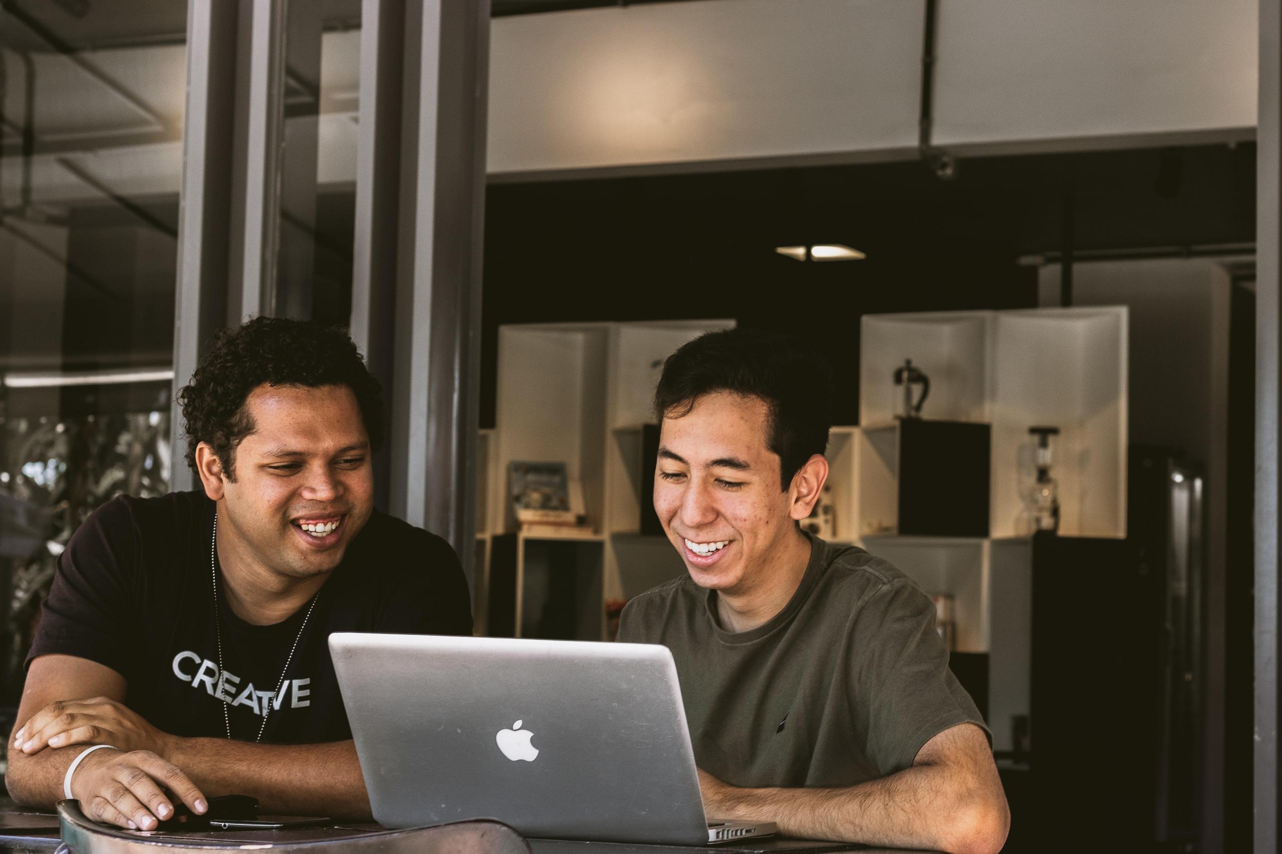two male students using laptop